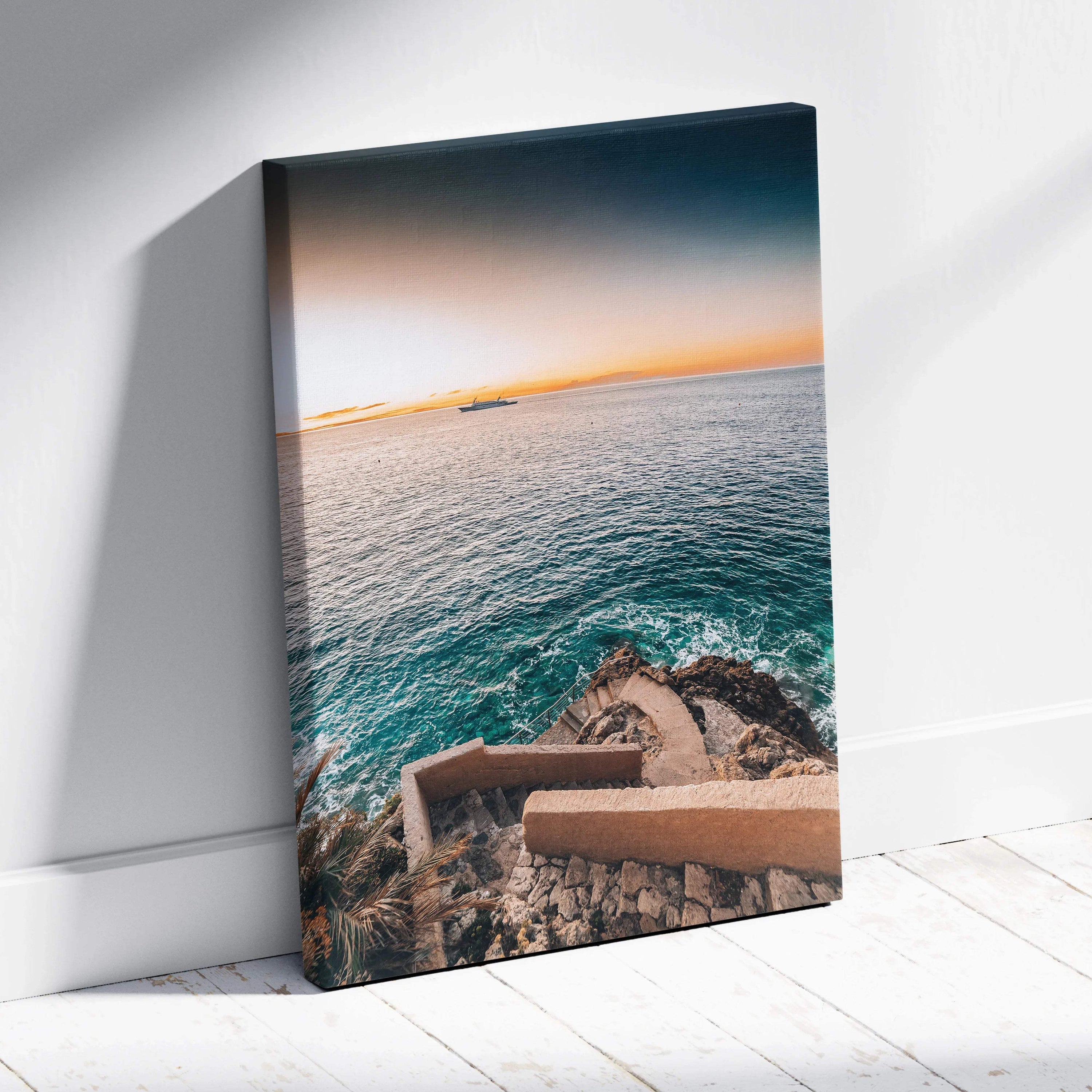 Canvas wall art featuring a coastal scene with rocky shore and blue ocean under a gradient sky at sunset.