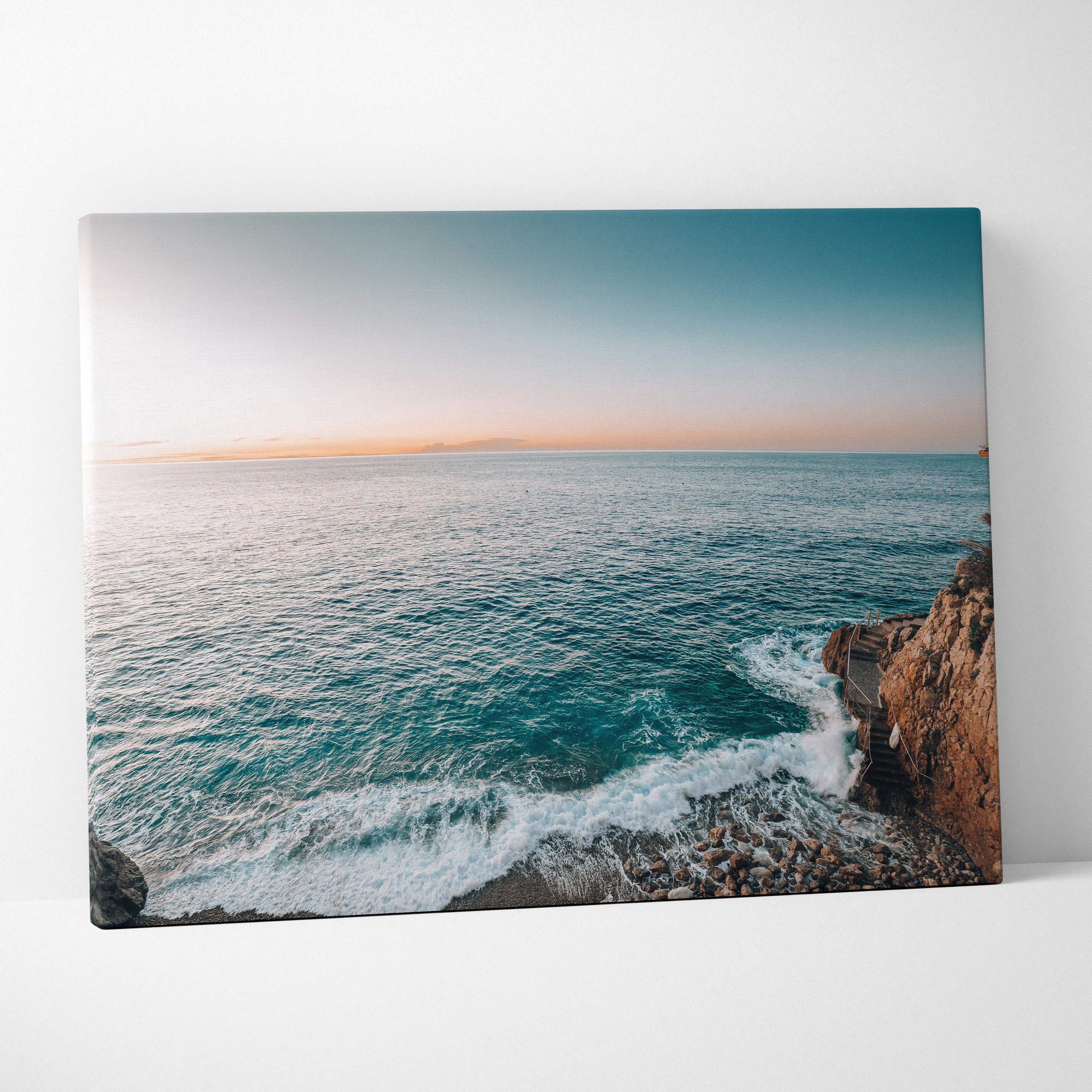 Coastal canvas wall art with turquoise waves on rocky cliffs at sunset