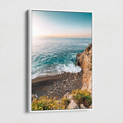 Canvas wall art featuring a tranquil beach scene with blue ocean waves, rocky shore, and sunset sky.