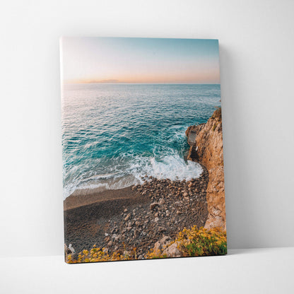 Canvas wall art featuring a serene beach scene with blue ocean waves, rocky shore, and soft pastel sky.