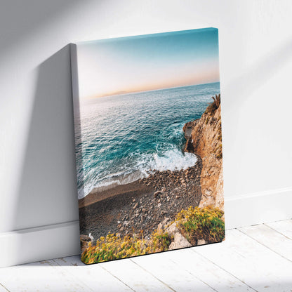 Canvas wall art featuring a serene beach scene with turquoise waves, rocky shore, and soft sunset sky.