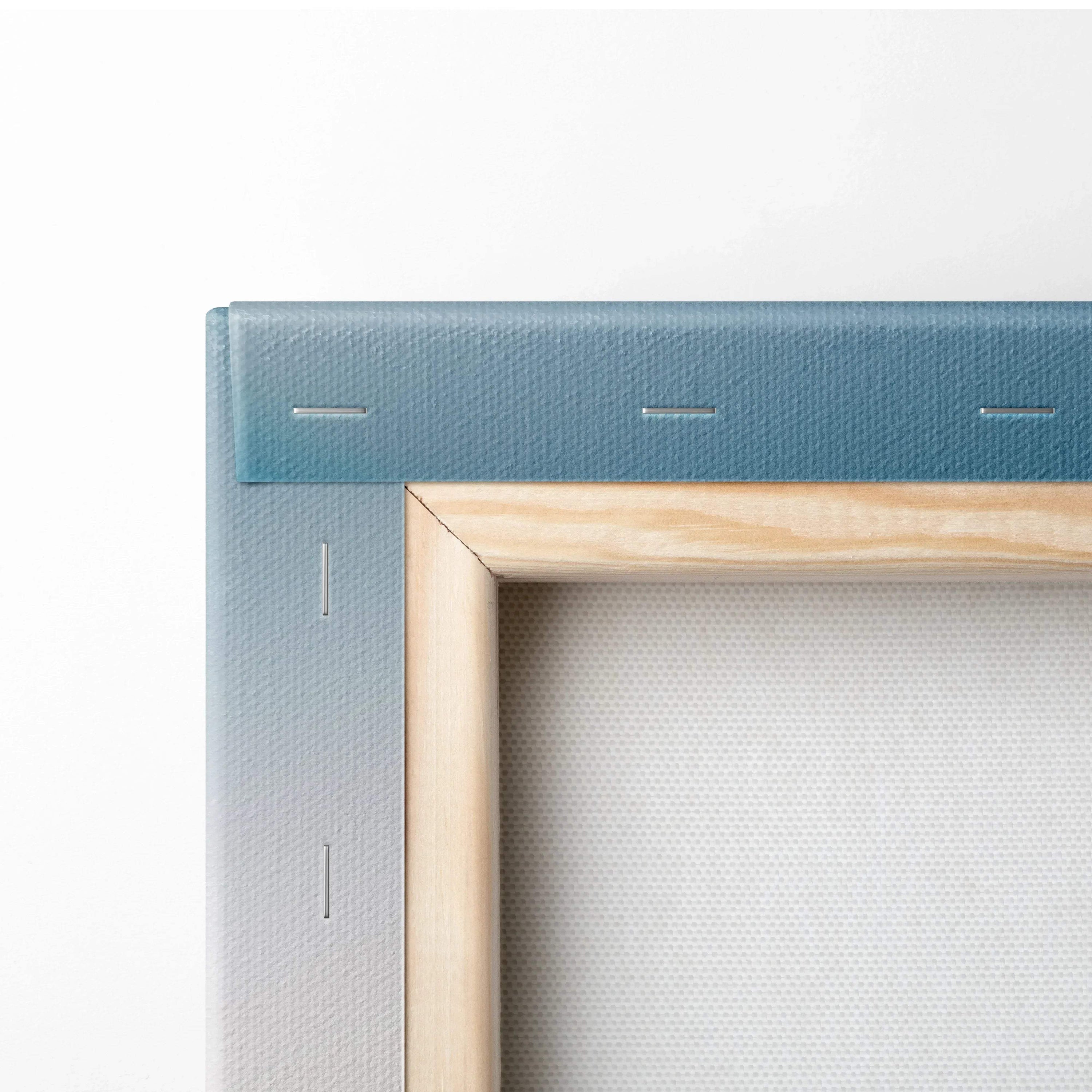 Close-up of stretched canvas corner with blue gradient background and natural wood frame edges.