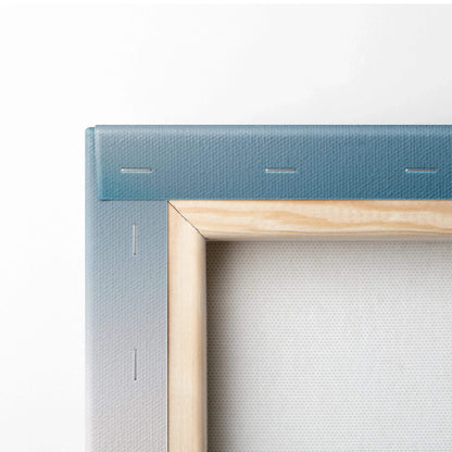 Close-up of stretched canvas corner with blue gradient background and natural wood frame edges.