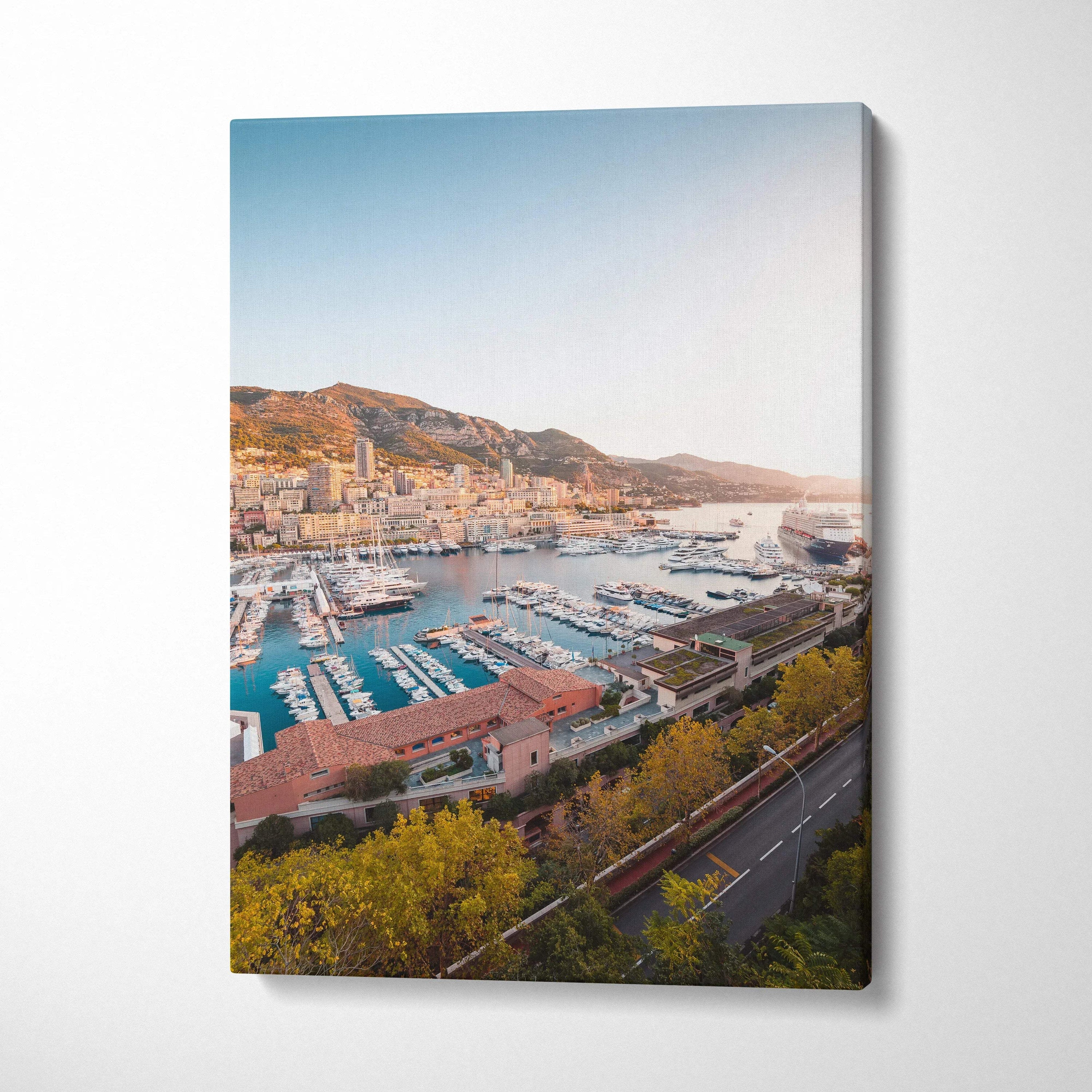 Canvas wall art featuring a sunlit marina and hillside town in warm tones.