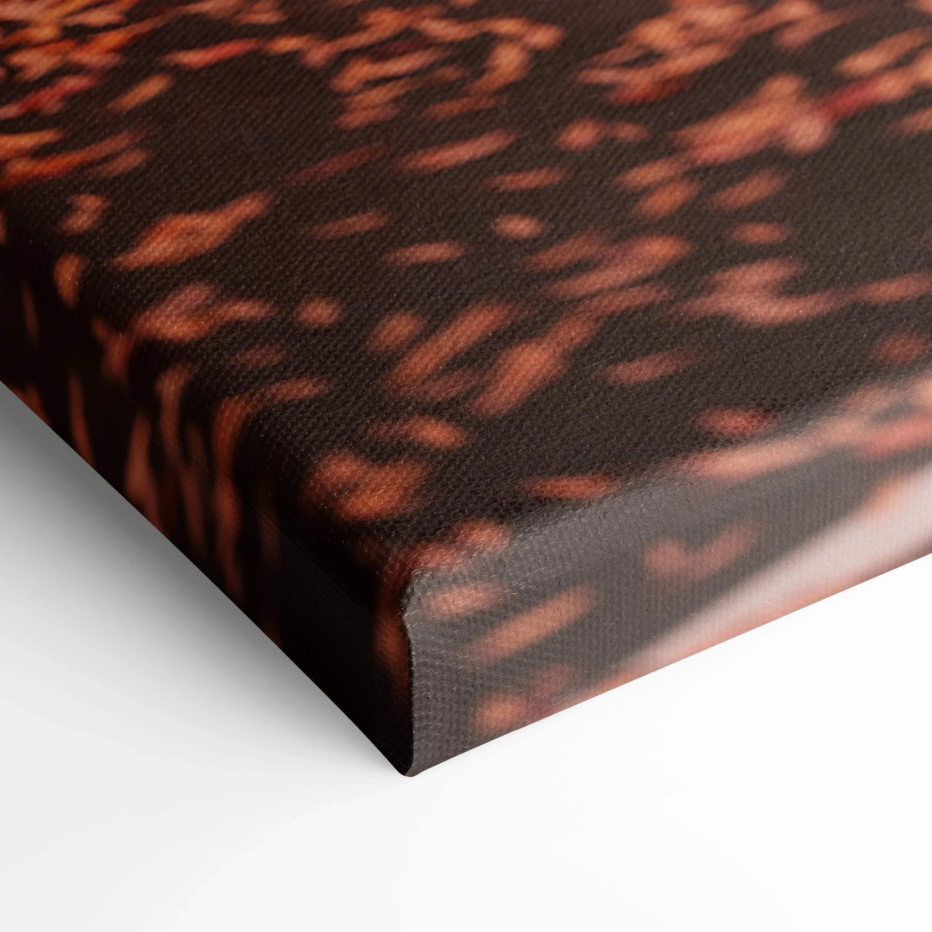 Close-up of textured canvas wall art with dark and reddish abstract design and wrapped edges.