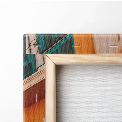 Corner of beige stretched canvas wall art print featuring abstract modern architectural shapes in teal and orange tones.