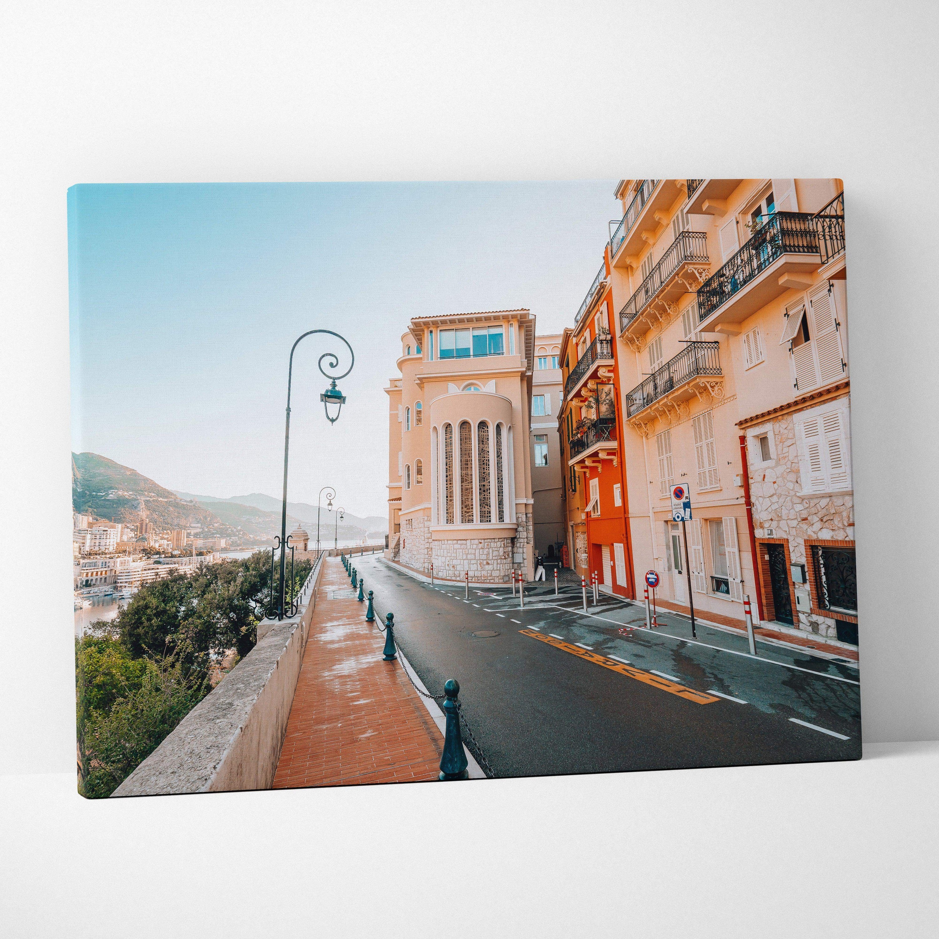Canvas wall art featuring a modern architectural street scene with warm-toned buildings and a clear blue sky.