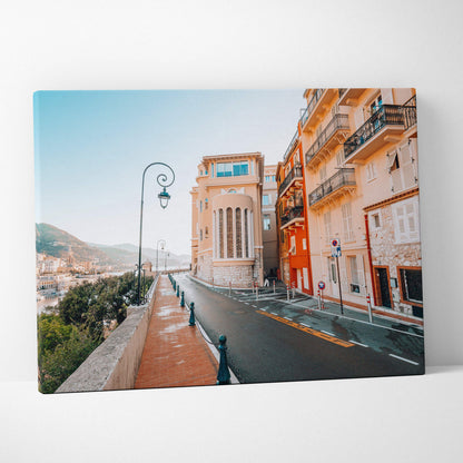 Canvas wall art featuring a modern architectural street scene with warm-toned buildings and a clear blue sky.