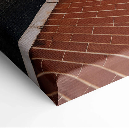 Close-up of textured canvas print featuring brick wall and architectural details in warm brown tones, stretched on wooden.
