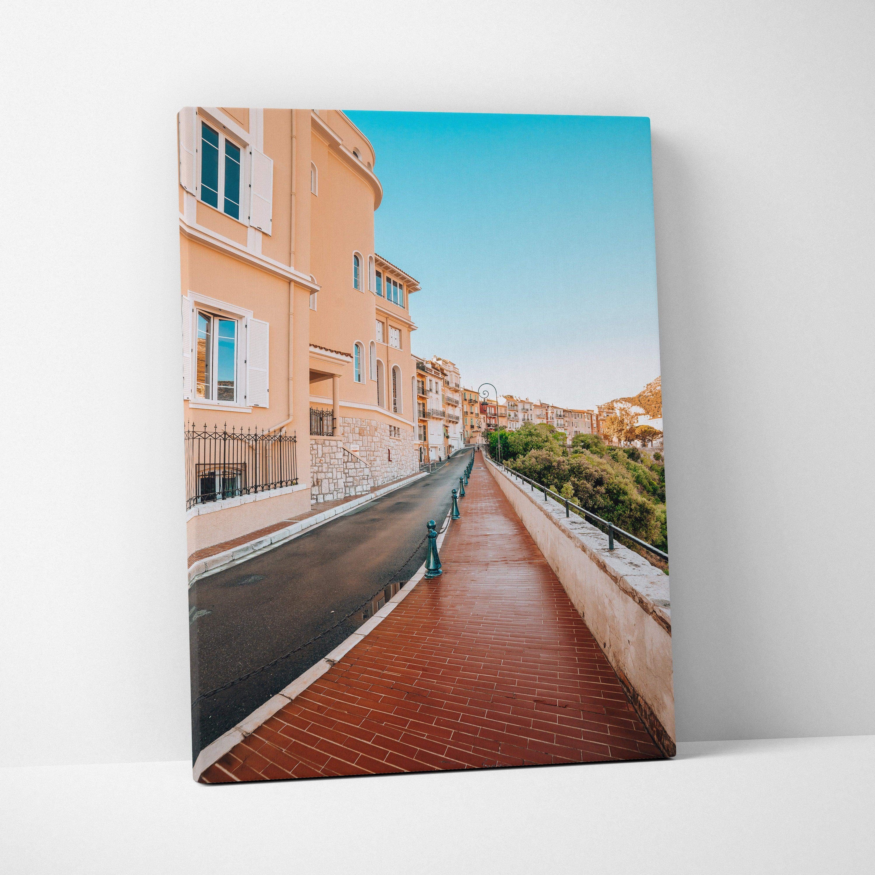 High-resolution canvas wall art featuring a bright urban street scene with pastel buildings and a clear blue sky.
