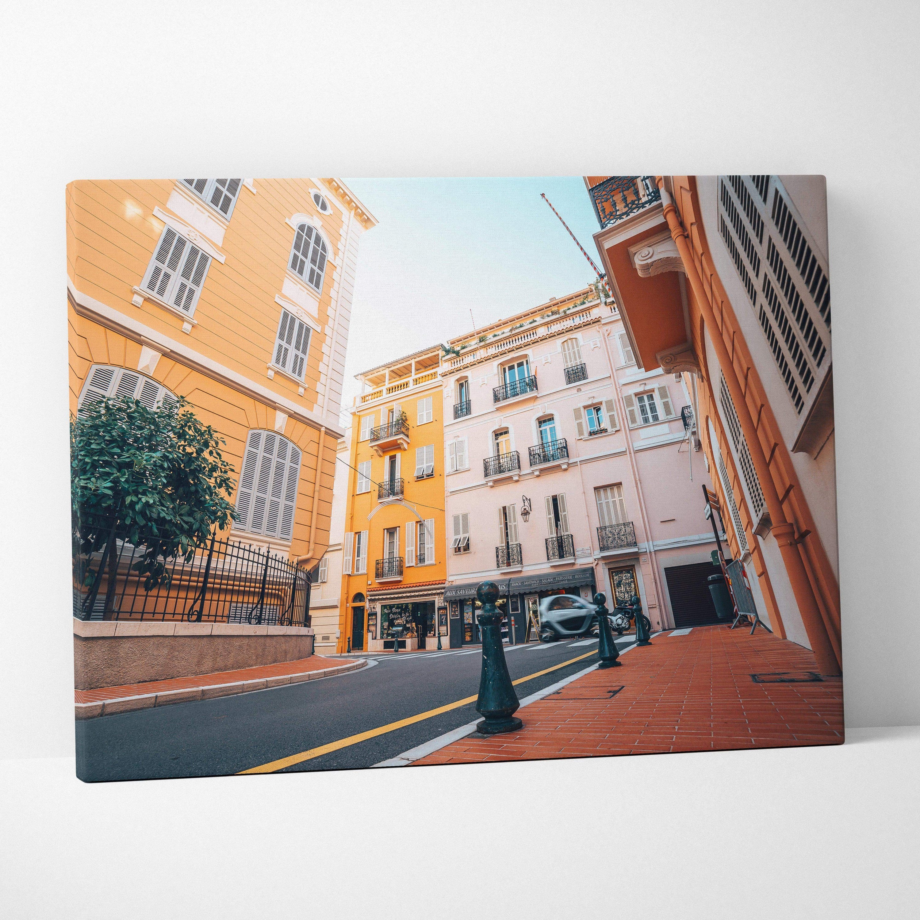 Canvas art wall decor featuring colorful European-style buildings on a street under a clear blue sky.