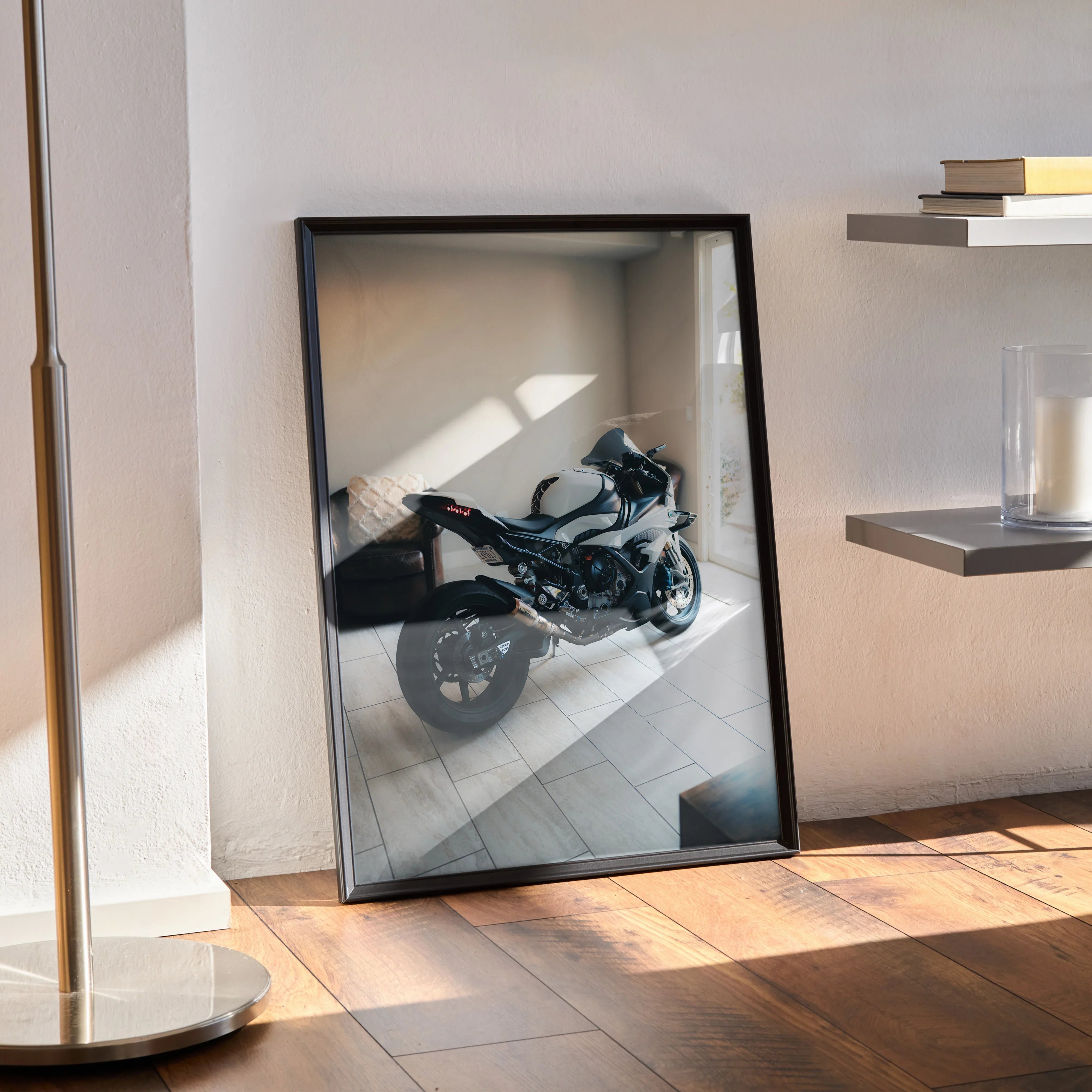 Framed BMW S1000RR motorcycle poster leaning against wall, modern room with sunlight and wooden floor.