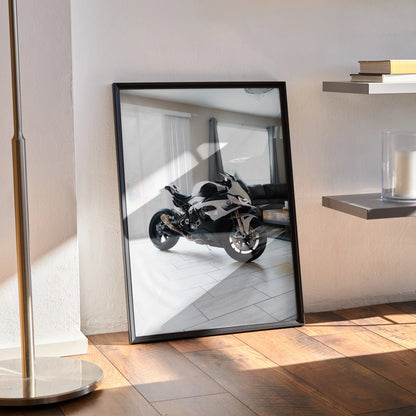 BMW S1000RR motorcycle poster in black frame leaning against wall, modern room setting wall art.