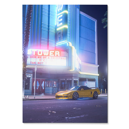 Acura NSX poster with yellow sports car parked in front of neon-lit vintage theater wall art.