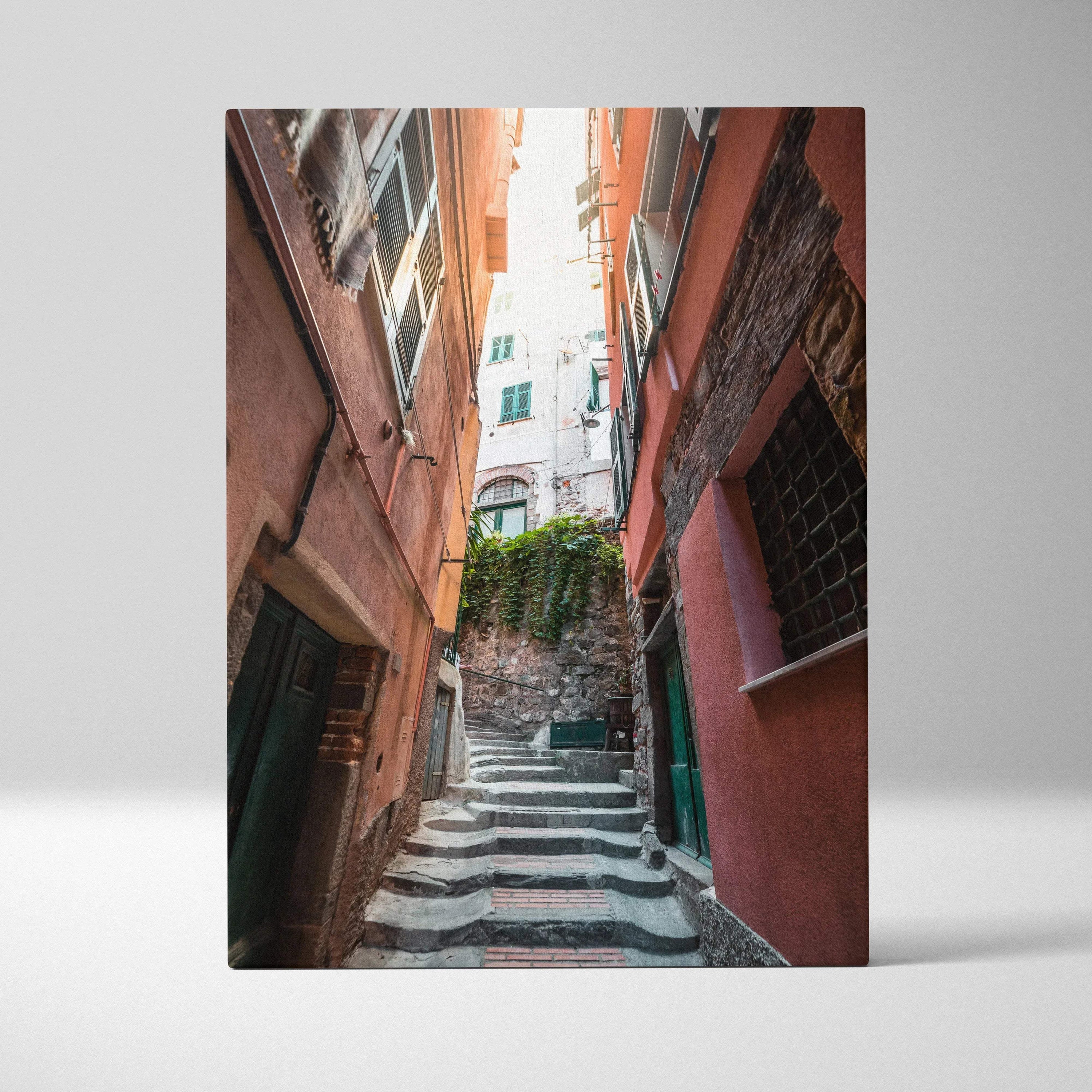Vertical canvas art of narrow European street with ascending stone steps and reddish walls.
