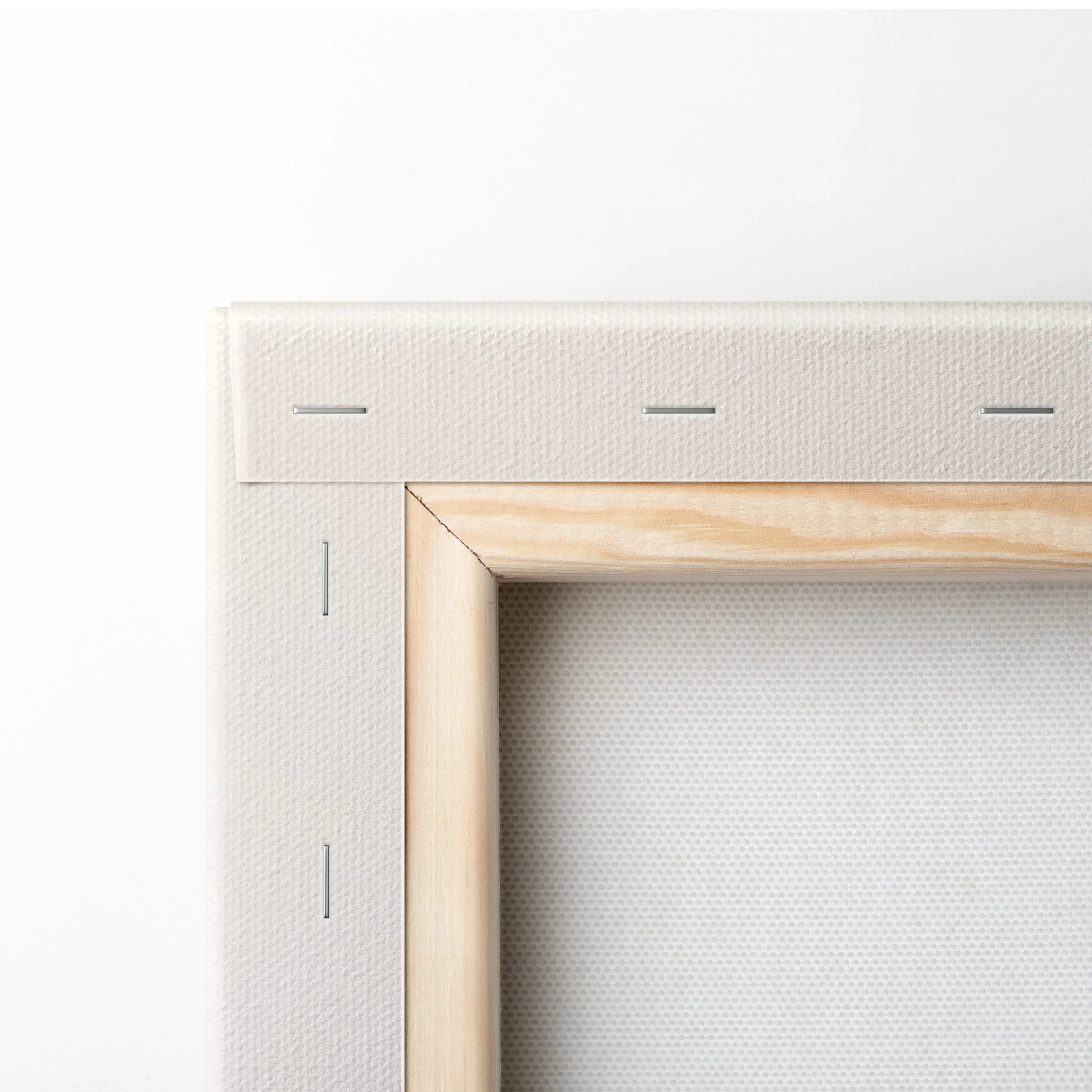 Close-up of wooden frame and white canvas texture on stretched wall art canvas.