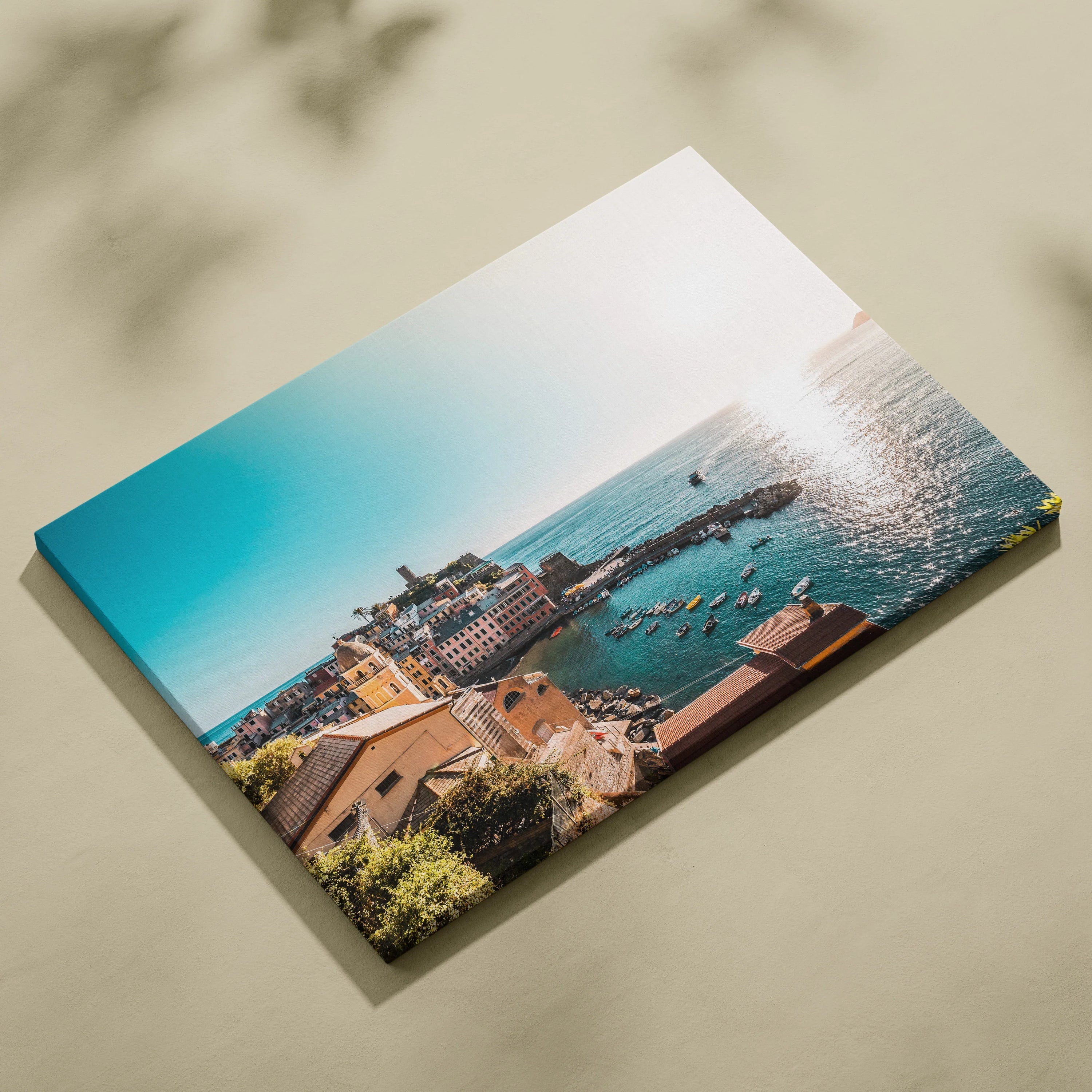 Coastal cityscape with detailed buildings and ocean view canvas wall art in bright sunlight.