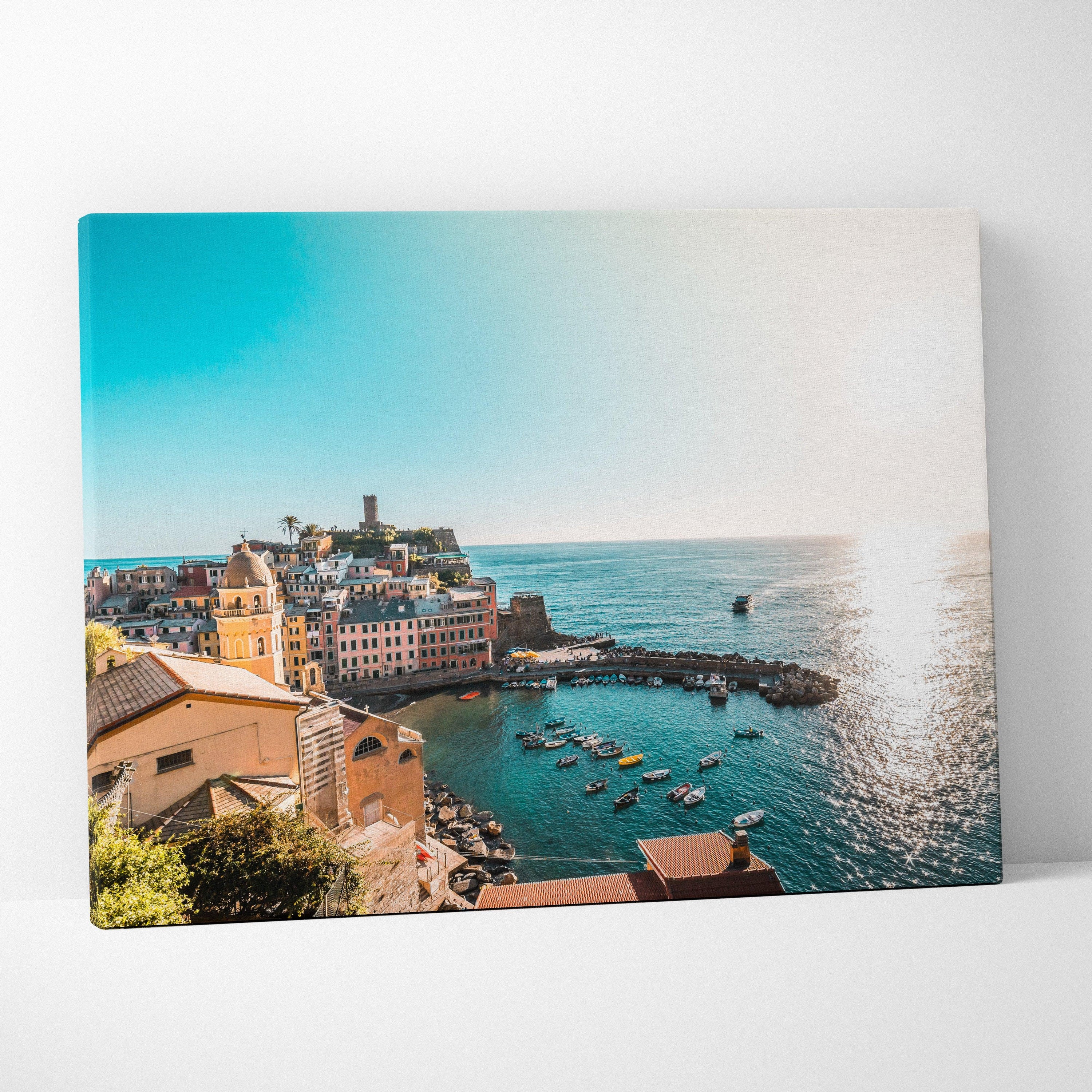 Canvas wall art depicting coastal architecture with colorful buildings by a bright blue ocean under clear sky.