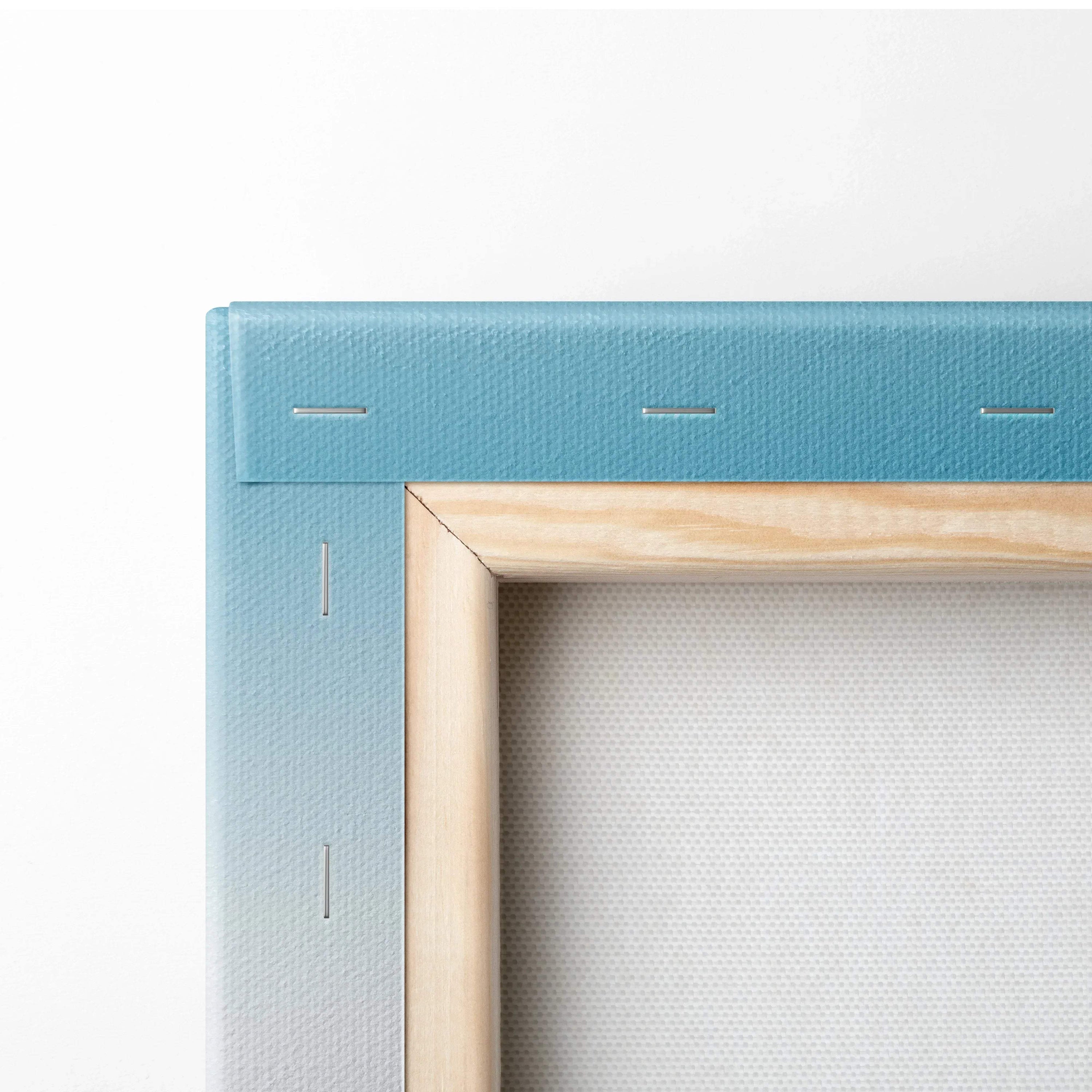 Close-up of canvas corner with light blue fabric stretched over wooden frame, showing texture and staples.