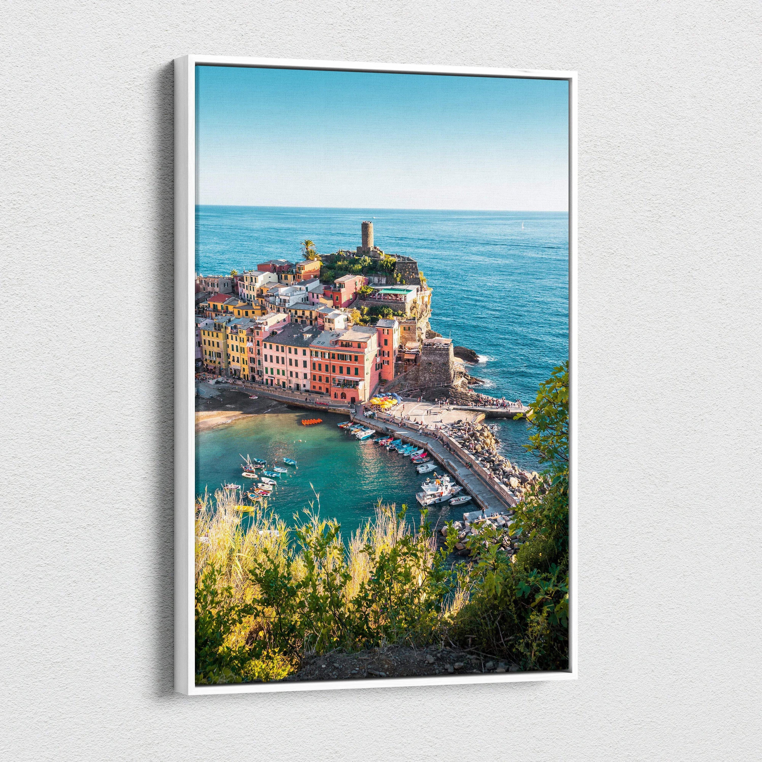 Framed canvas wall art featuring colorful coastal buildings and a lighthouse under a clear blue sky.