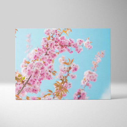 Vibrant pink flower floral canvas wall art with bright blue sky background for elegant decor.