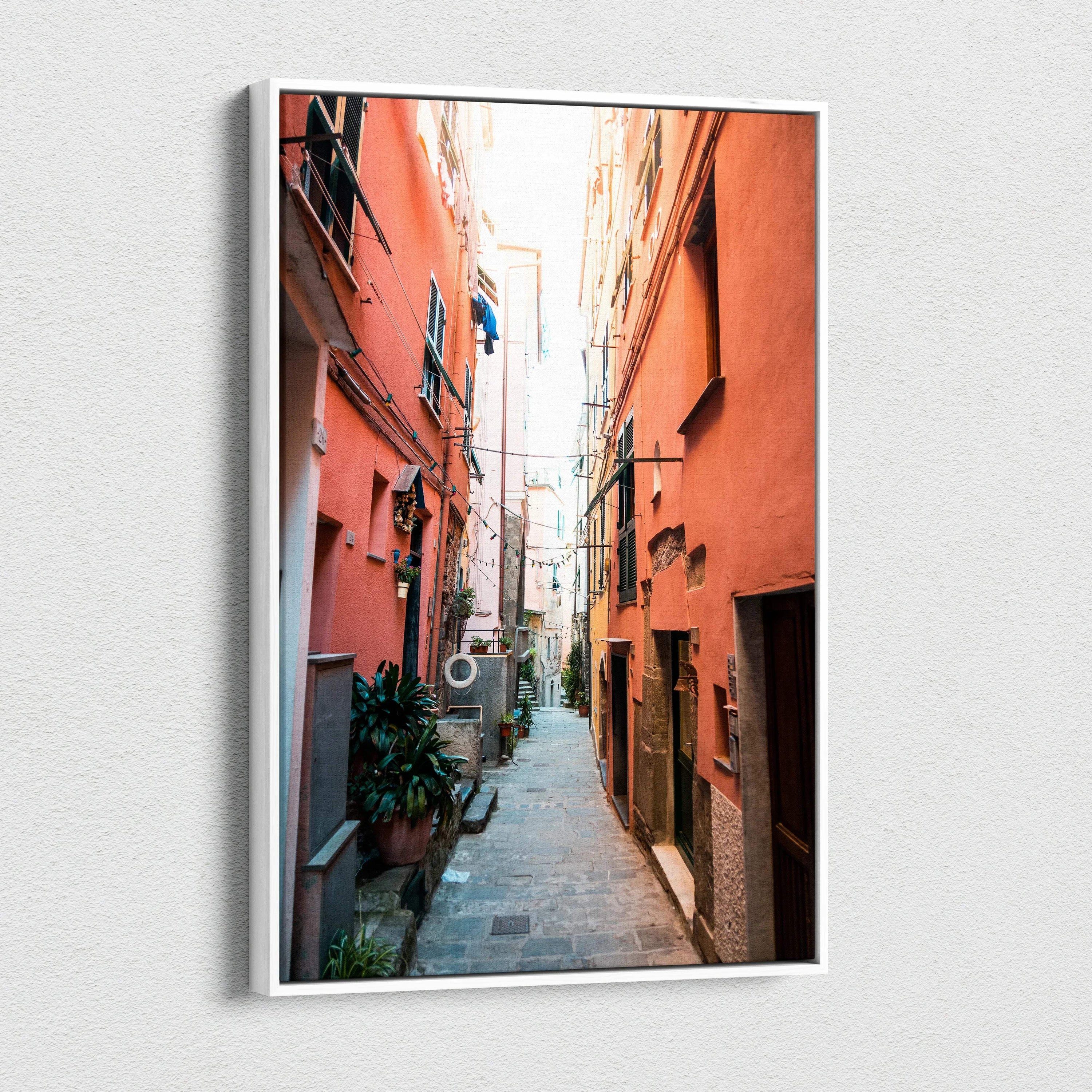 Vertical canvas wall art featuring a vibrant narrow alley with orange buildings and detailed architecture.