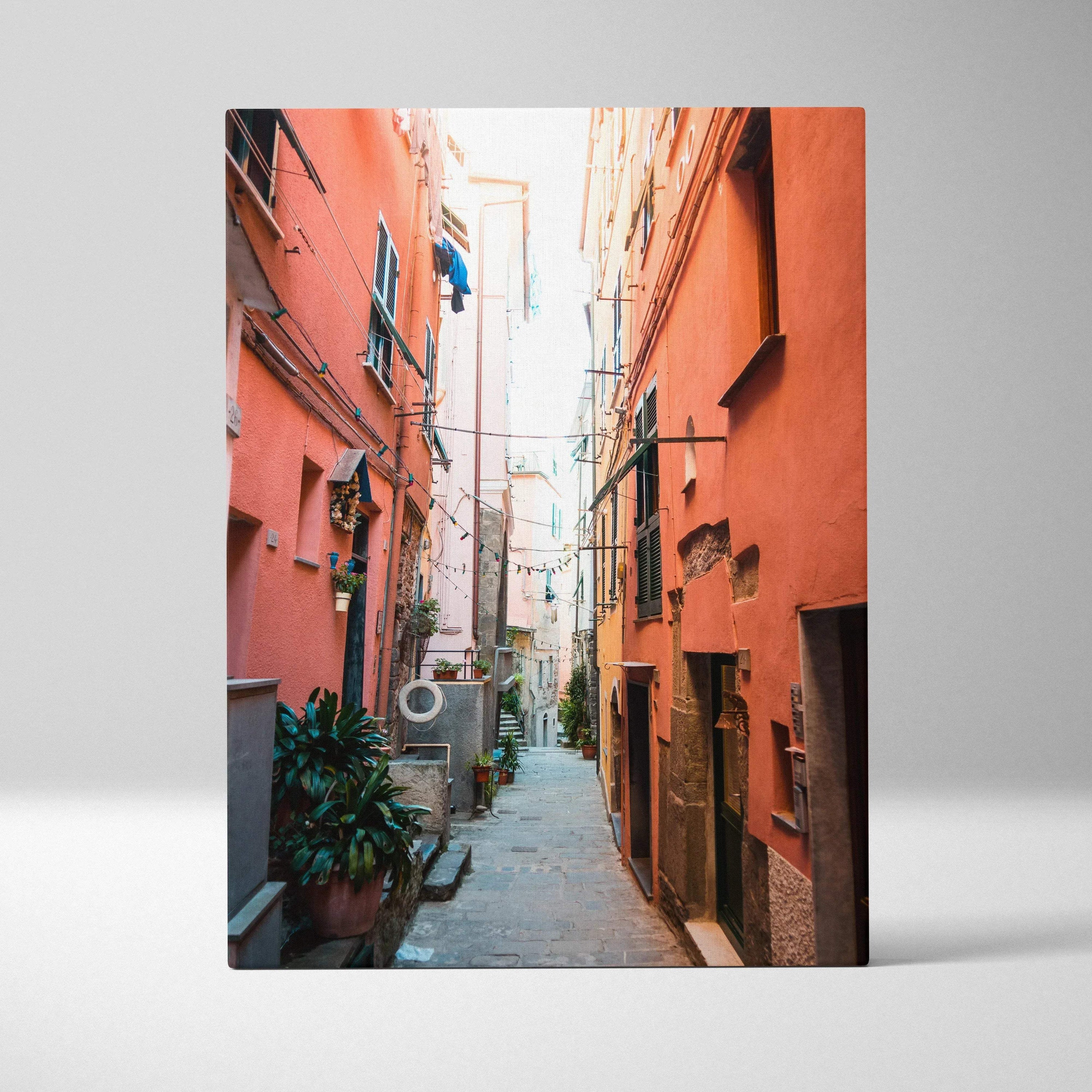 Vertical canvas wall art featuring a vibrant, high-resolution narrow alleyway with warm-toned buildings and urban details.