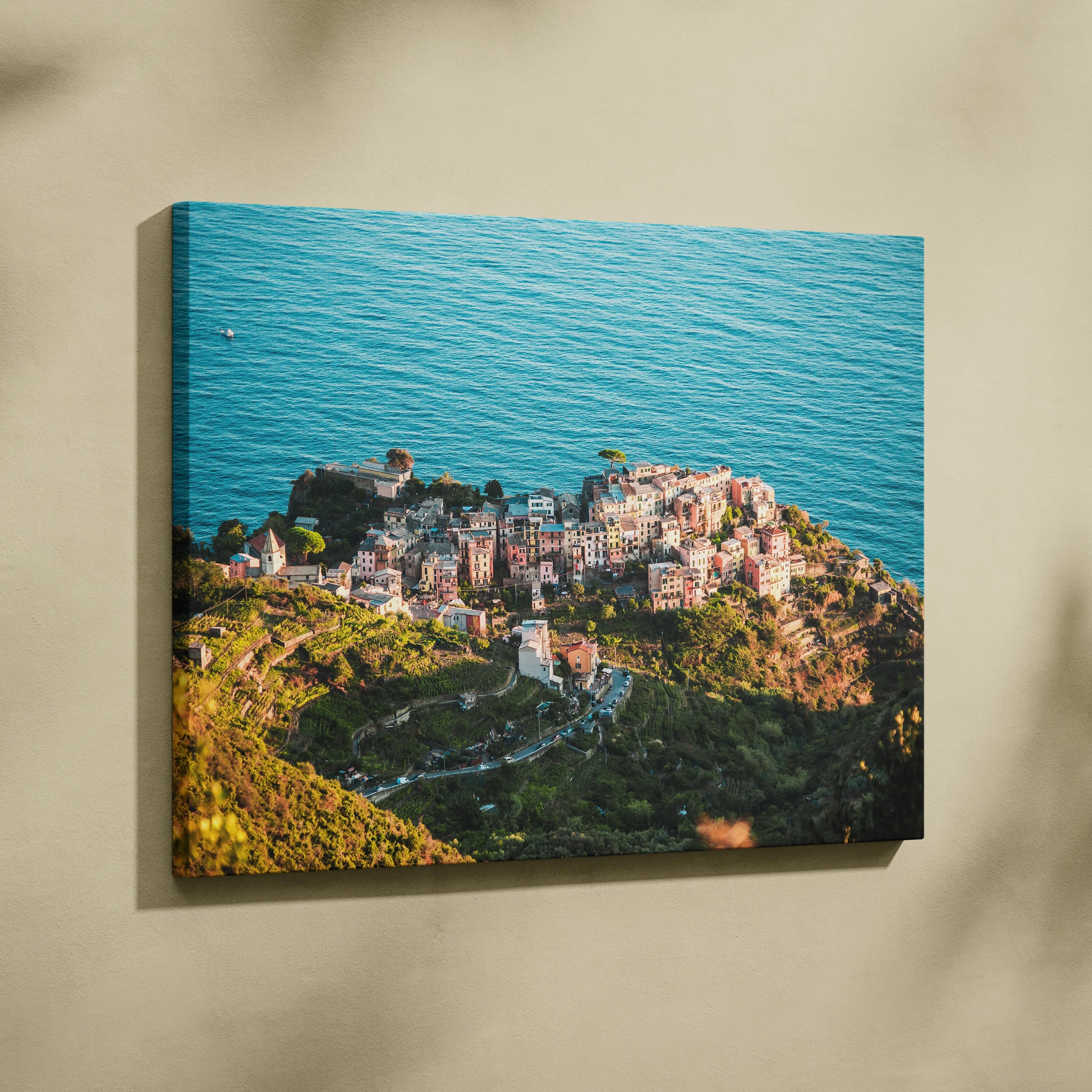 Canvas wall art of colorful coastal buildings surrounded by blue ocean and greenery.