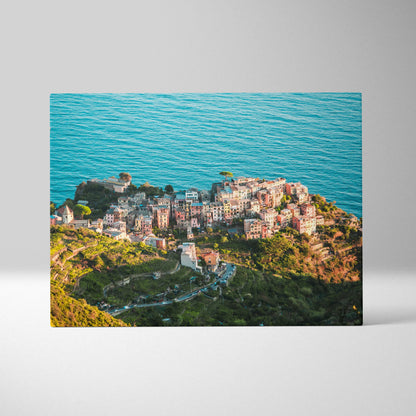 Canvas wall art featuring a coastal town with colorful buildings perched on cliffs above a vibrant blue ocean.