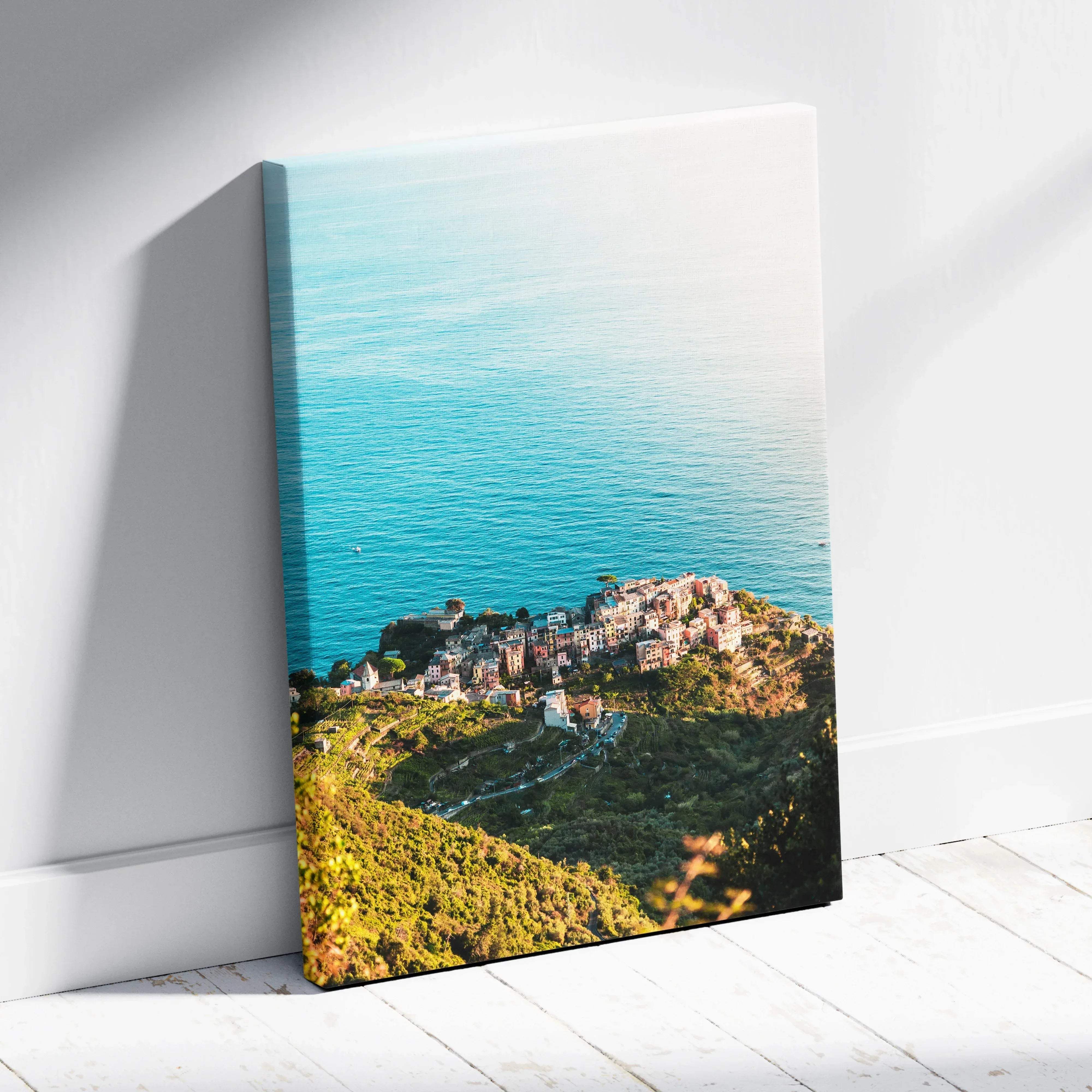 A vibrant canvas print of a coastal village on green hills overlooking turquoise waters perfect for wall art decor
