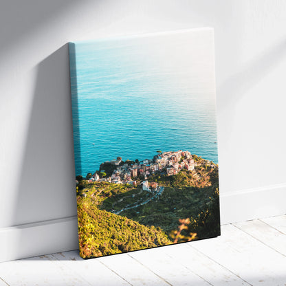 Vertical canvas wall art featuring coastal architecture and ocean view with vibrant green and blue tones.