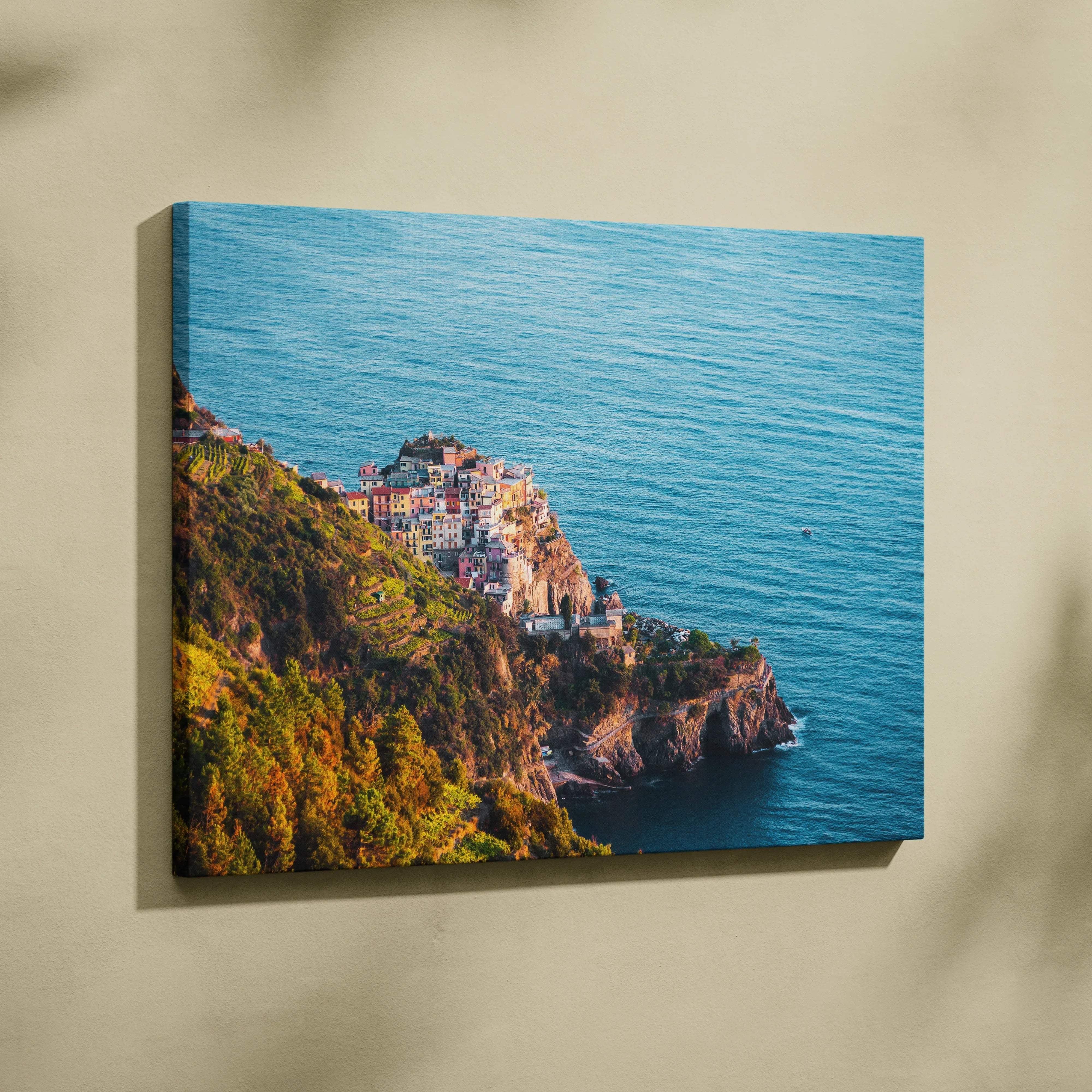 A vibrant canvas wall art of a colorful coastal cliffside village overlooking turquoise ocean waters in serene blues