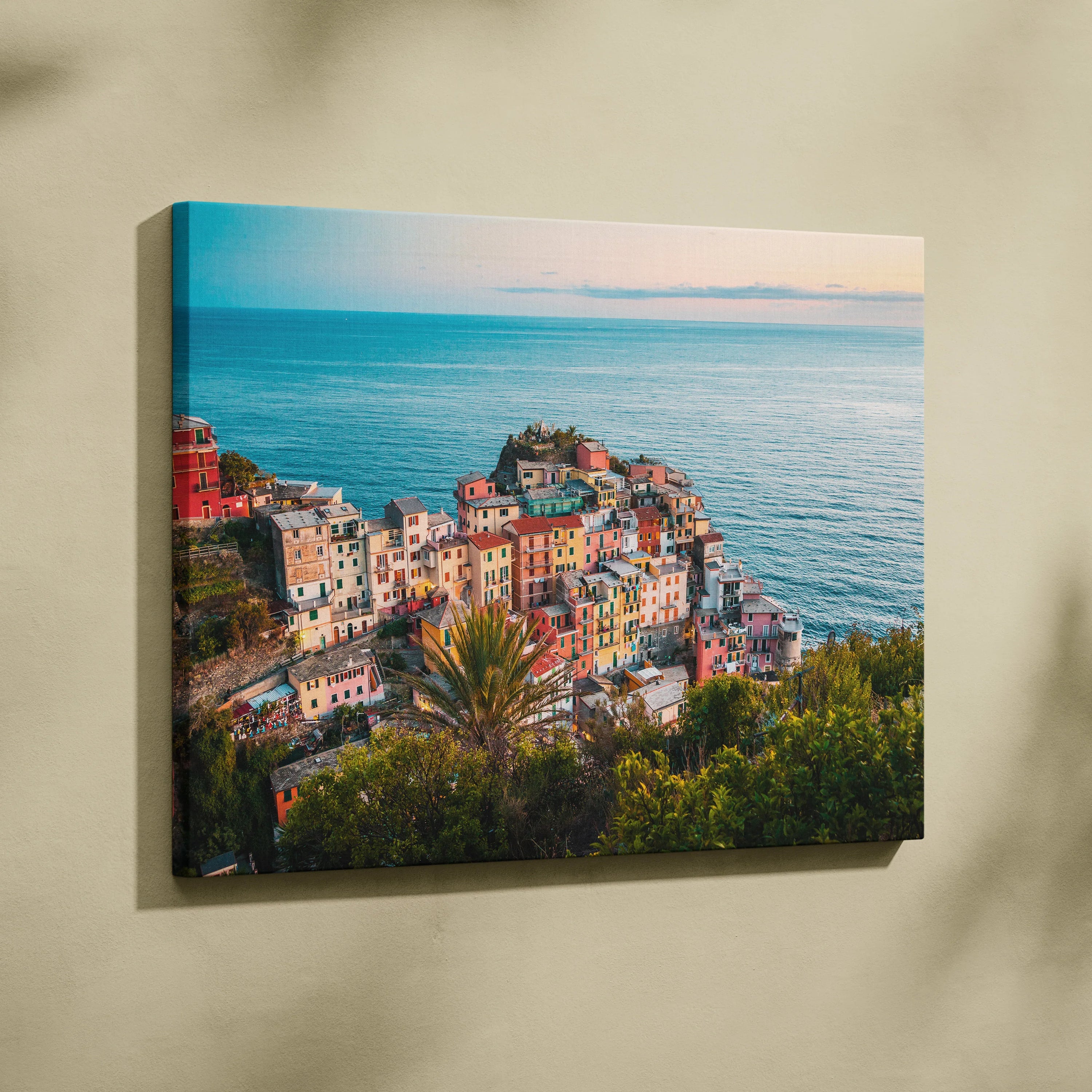 Canvas wall art featuring colorful coastal buildings overlooking a calm blue ocean at sunset.