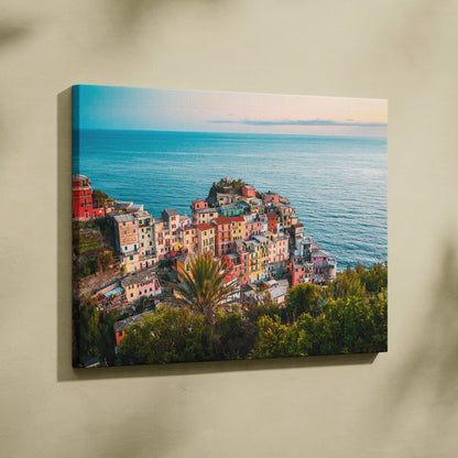 Canvas wall art featuring colorful coastal buildings overlooking a calm blue ocean at sunset.