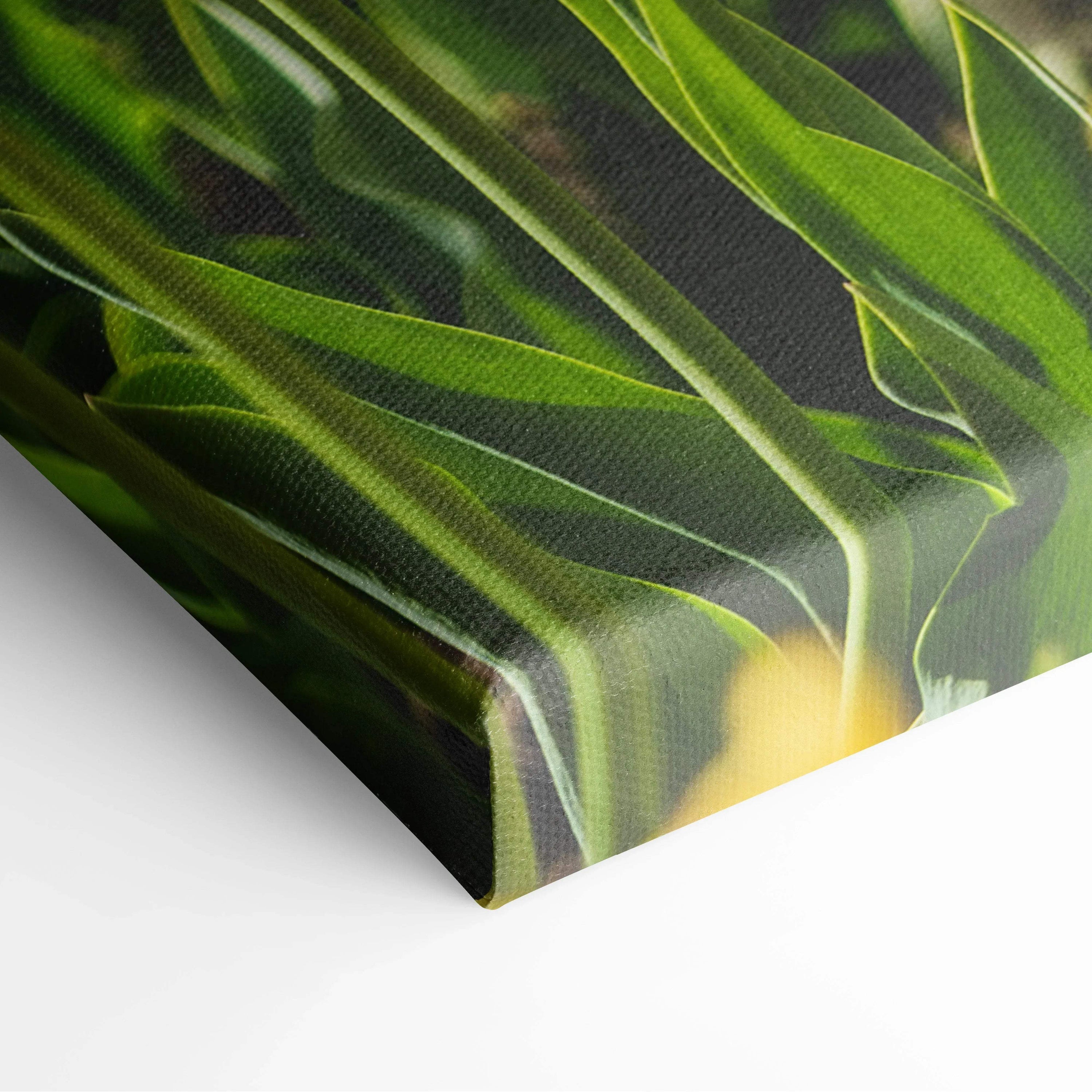Close-up of canvas wall art featuring detailed yellow tulip petals and green leaves for vibrant home decor.