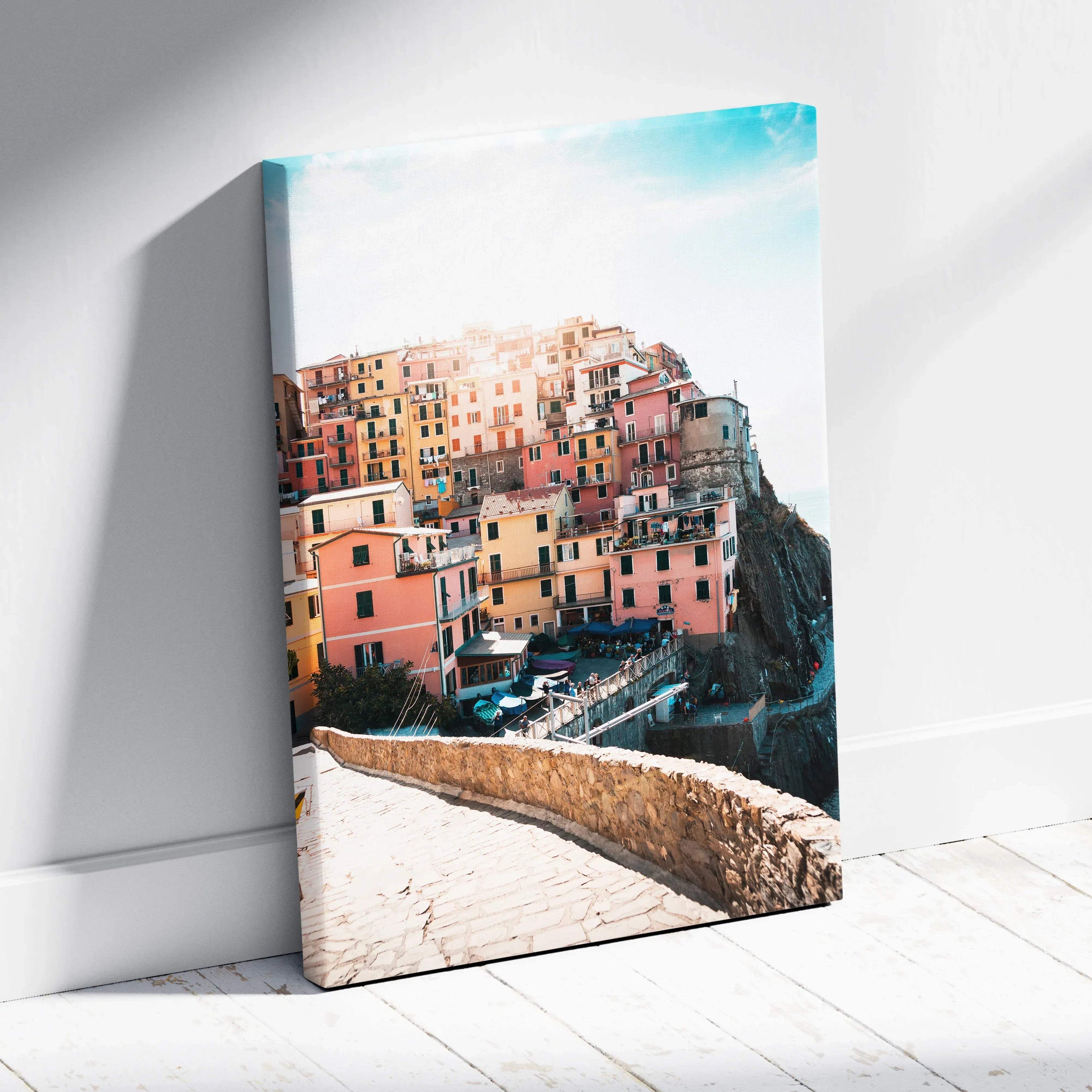 Vertical canvas wall art featuring colorful seaside buildings with bright blue sky backdrop.