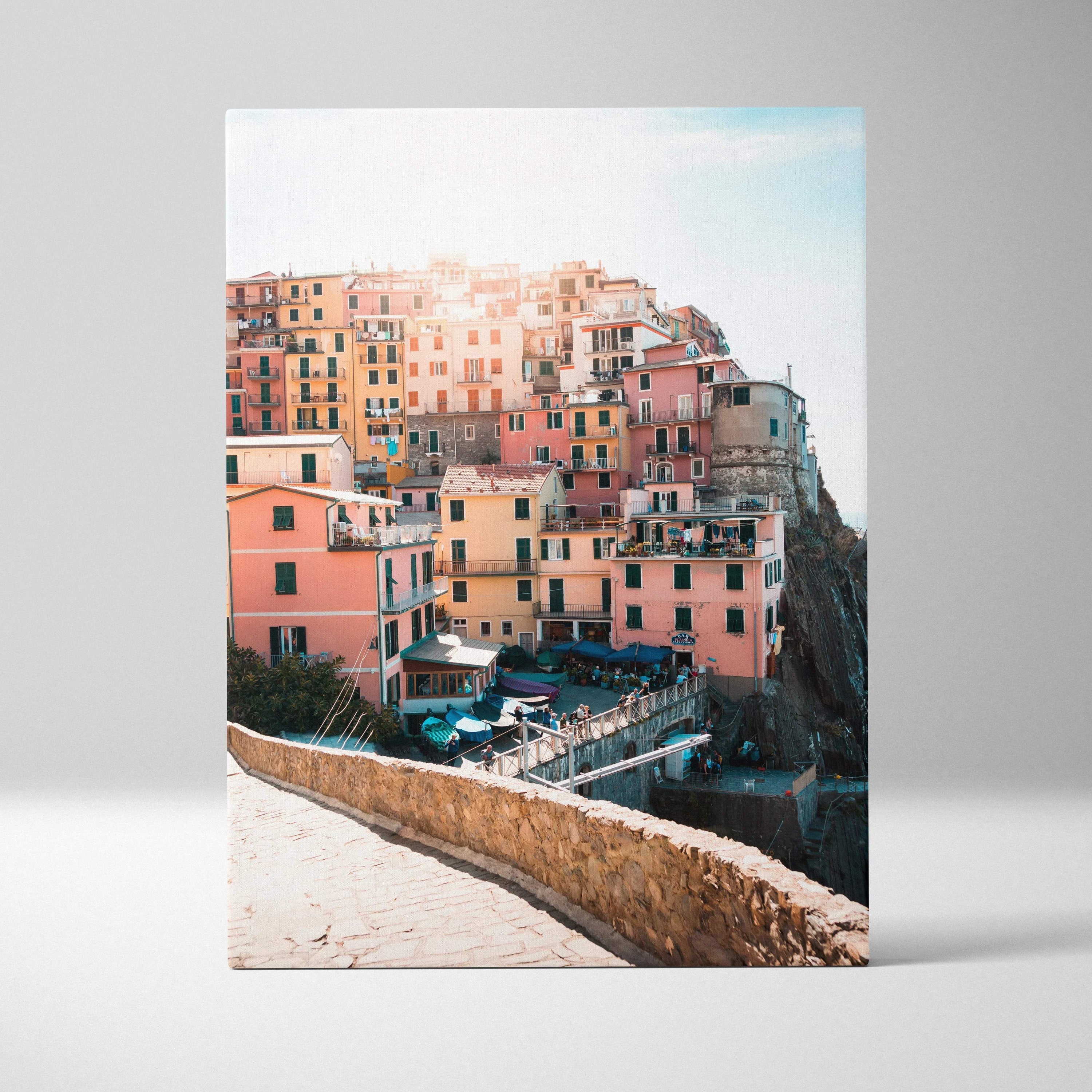 High-resolution vertical canvas art of colorful coastal buildings stacked on cliffs with soft sunlight, wall art for modern.