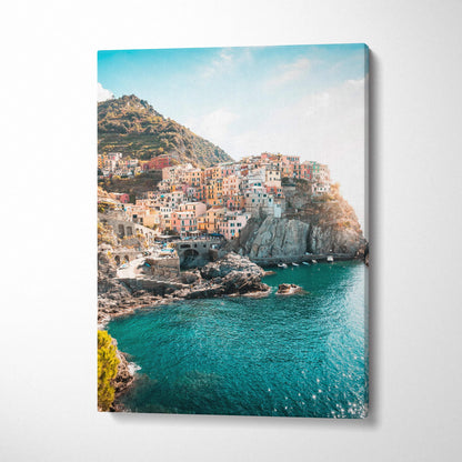 Coastal village canvas wall art with colorful buildings on rocky cliffs and turquoise water.