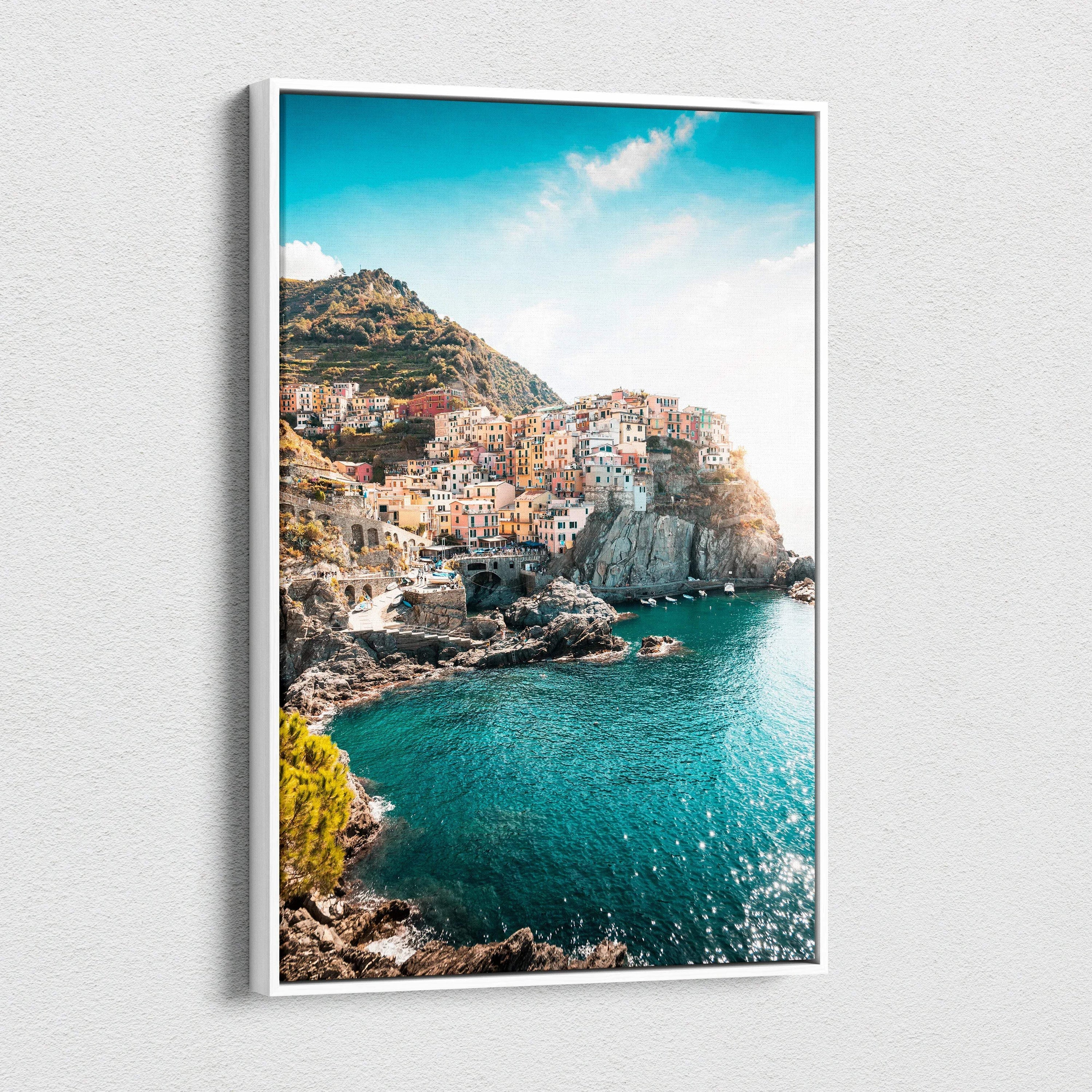 Canvas wall art depicting colorful cliffside buildings by a bright turquoise sea under a clear blue sky.