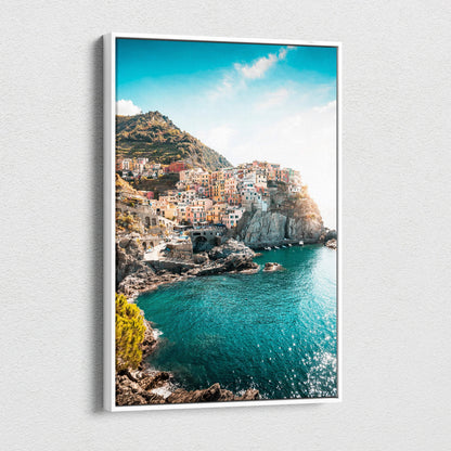 Canvas wall art depicting colorful cliffside buildings by a bright turquoise sea under a clear blue sky.