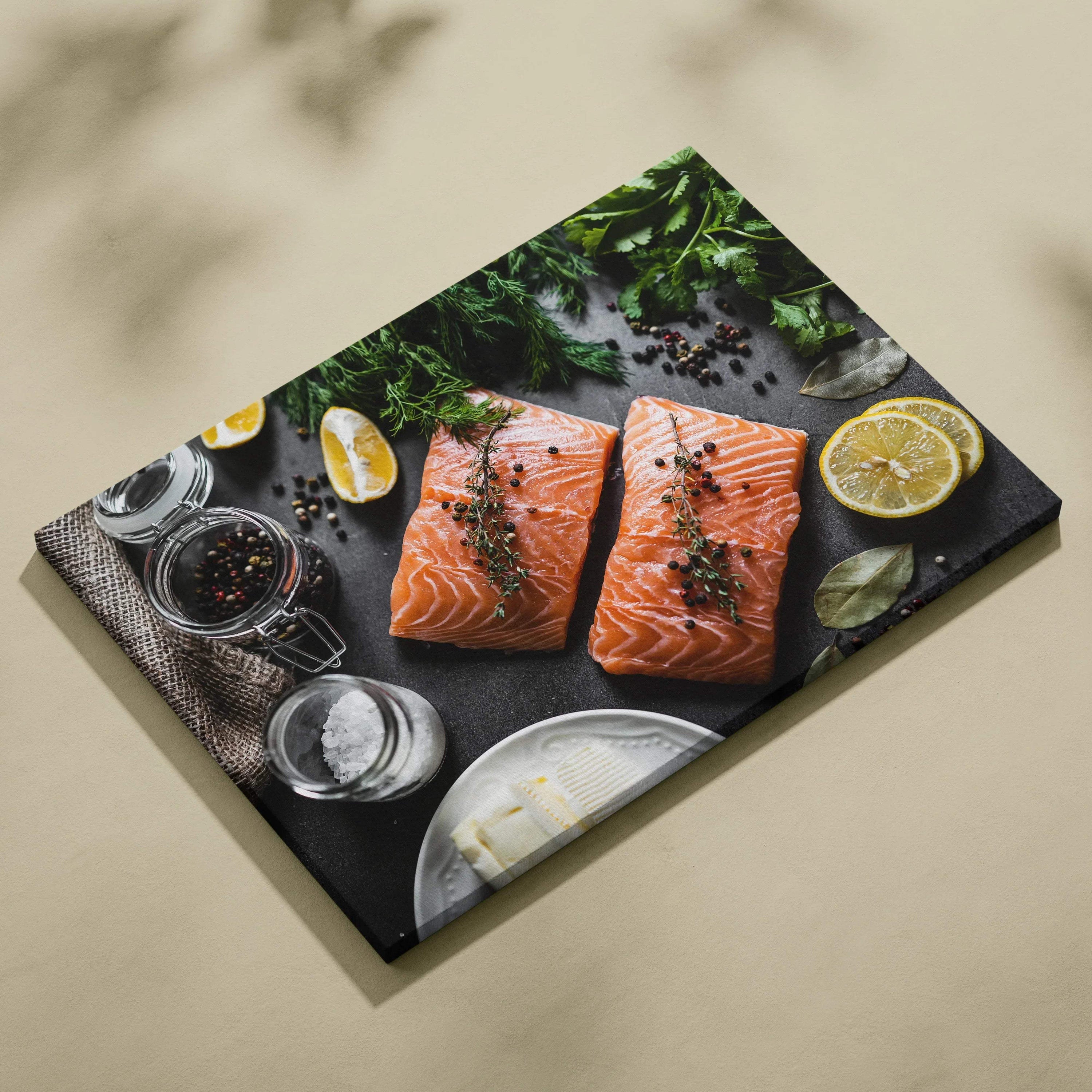 Canvas wall art featuring two seasoned raw salmon fillets on a black slate with lemon slices, herbs, and spices for home.