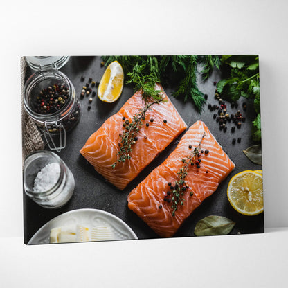 Canvas wall art featuring two vibrant salmon fillets seasoned with herbs and peppercorns, surrounded by lemon wedges and.