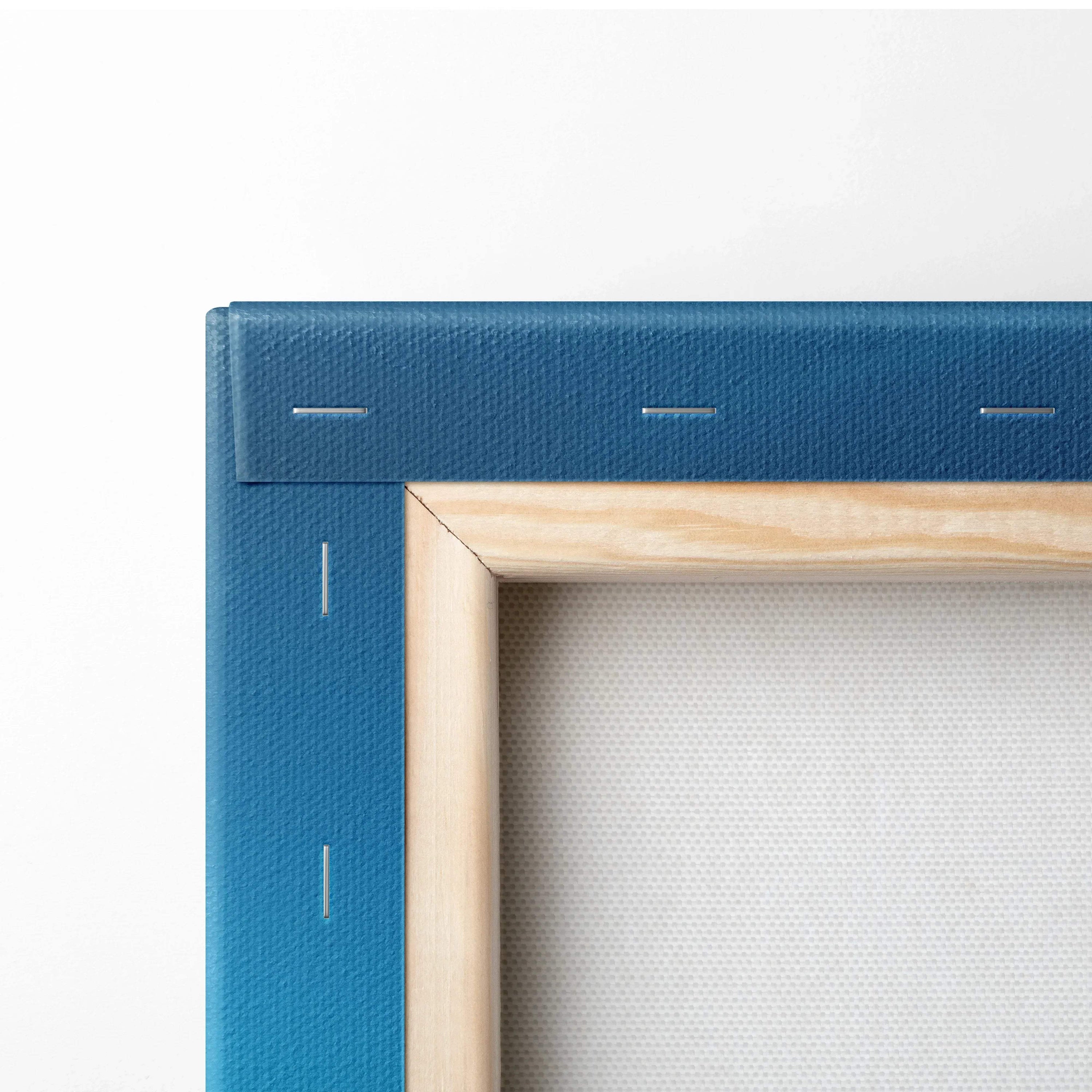 Close-up of blue fabric-wrapped canvas corner with natural wood frame and white stretched canvas surface.