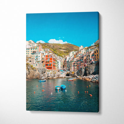 Vertical canvas wall art featuring colorful hillside buildings overlooking a serene harbor with boats under a clear blue sky.