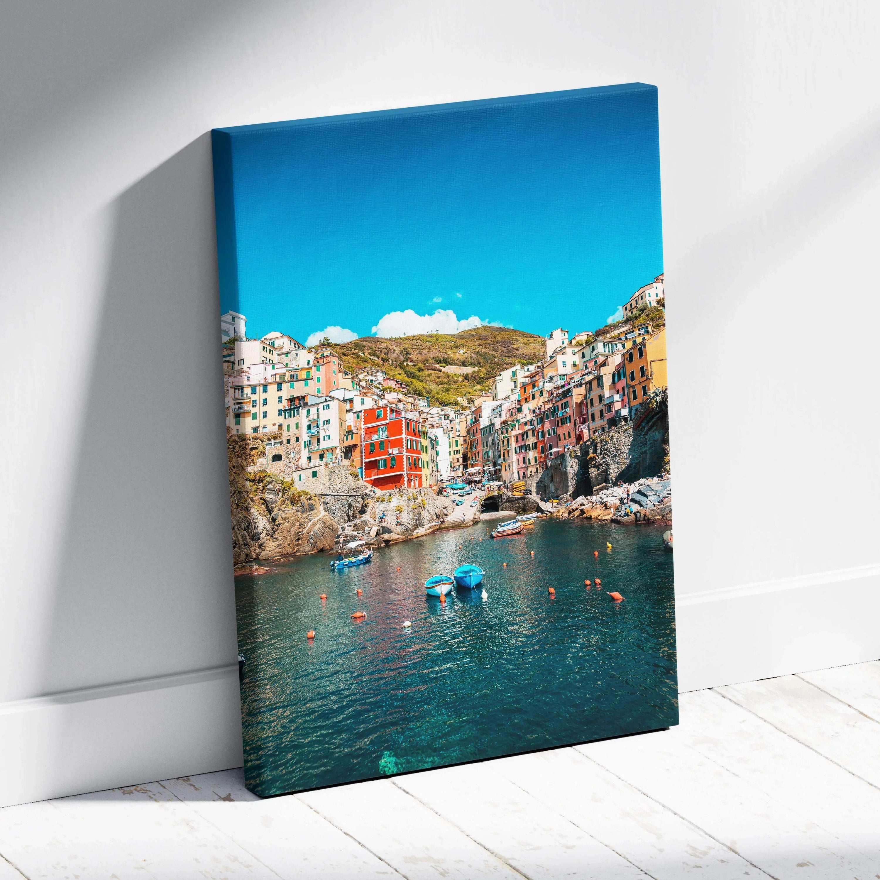 Vertical canvas wall art featuring colorful buildings by a waterfront under a blue sky.