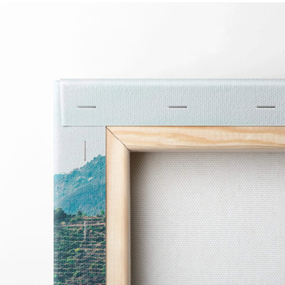Close-up of stretched canvas wall art with natural wood frame corner and subtle blue and green architectural print visible.