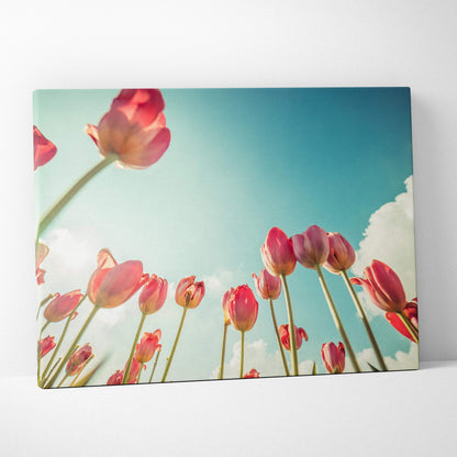 Canvas wall art featuring vibrant red tulips with green stems against a bright blue sky with white clouds.