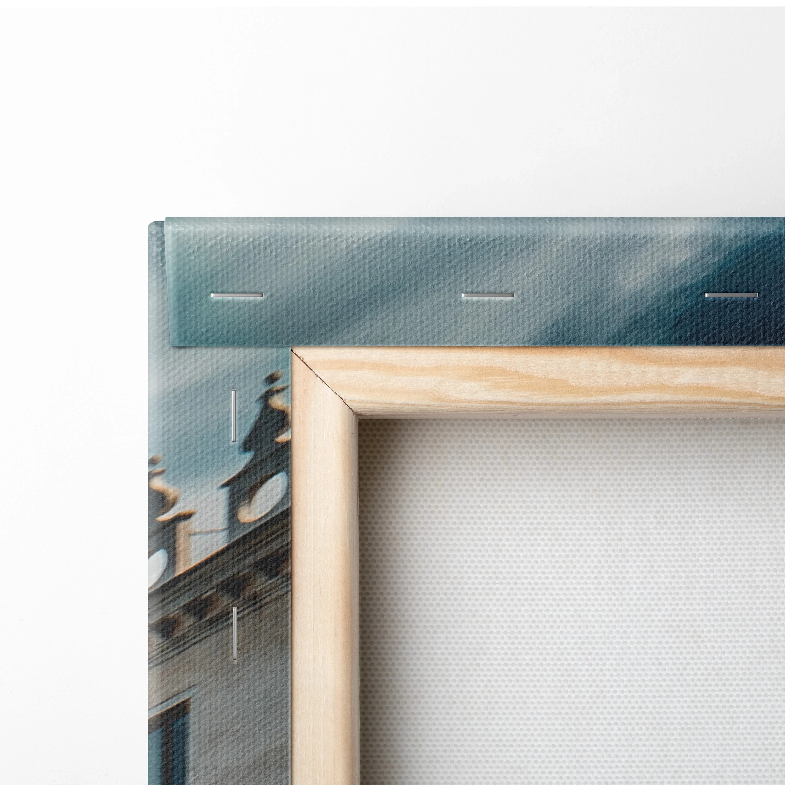 Close-up of canvas art with wooden frame showing architectural building and ocean elements in blue and gray tones.