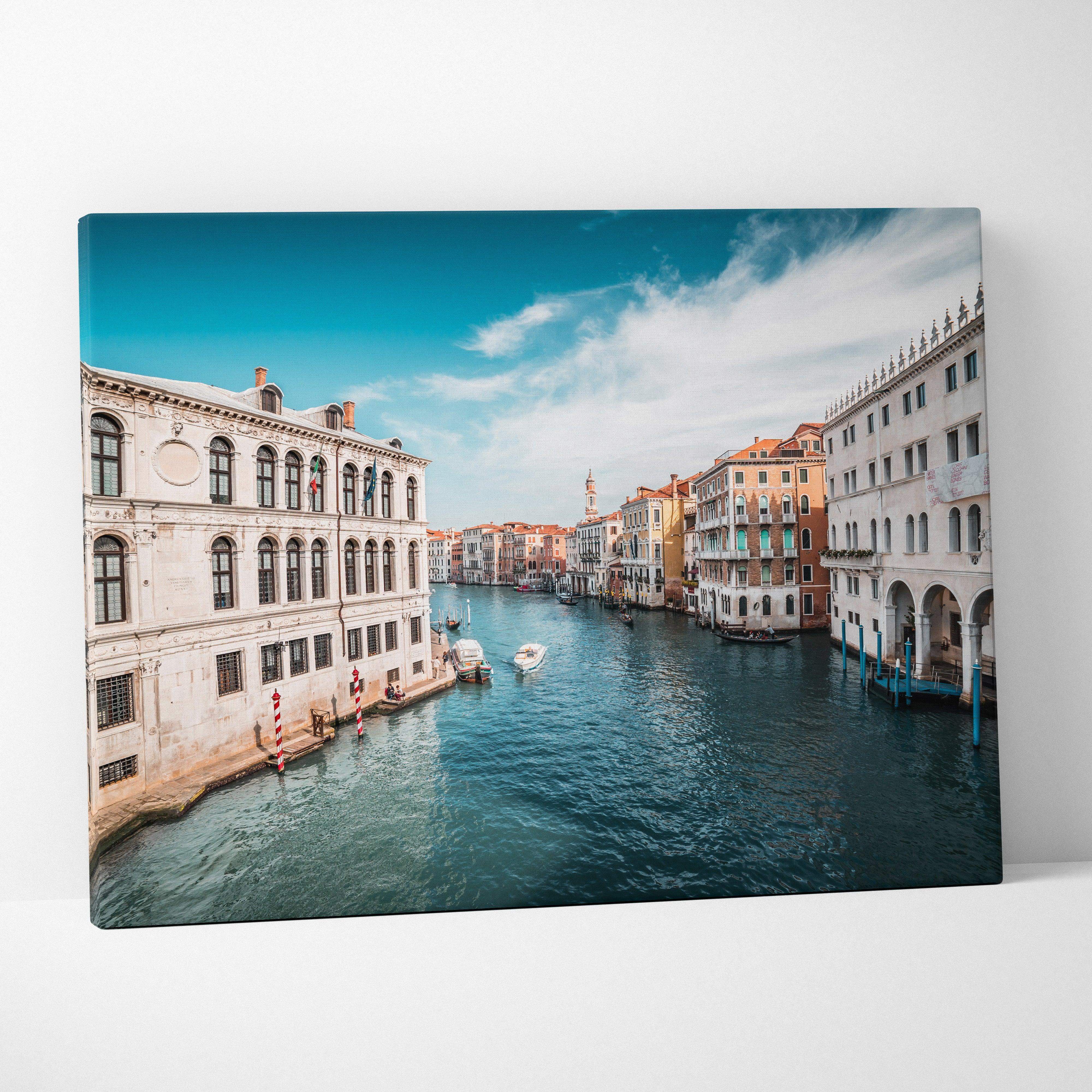 Vibrant blue canvas wall art featuring a venice canal cityscape with historic buildings and gondolas for calming decor