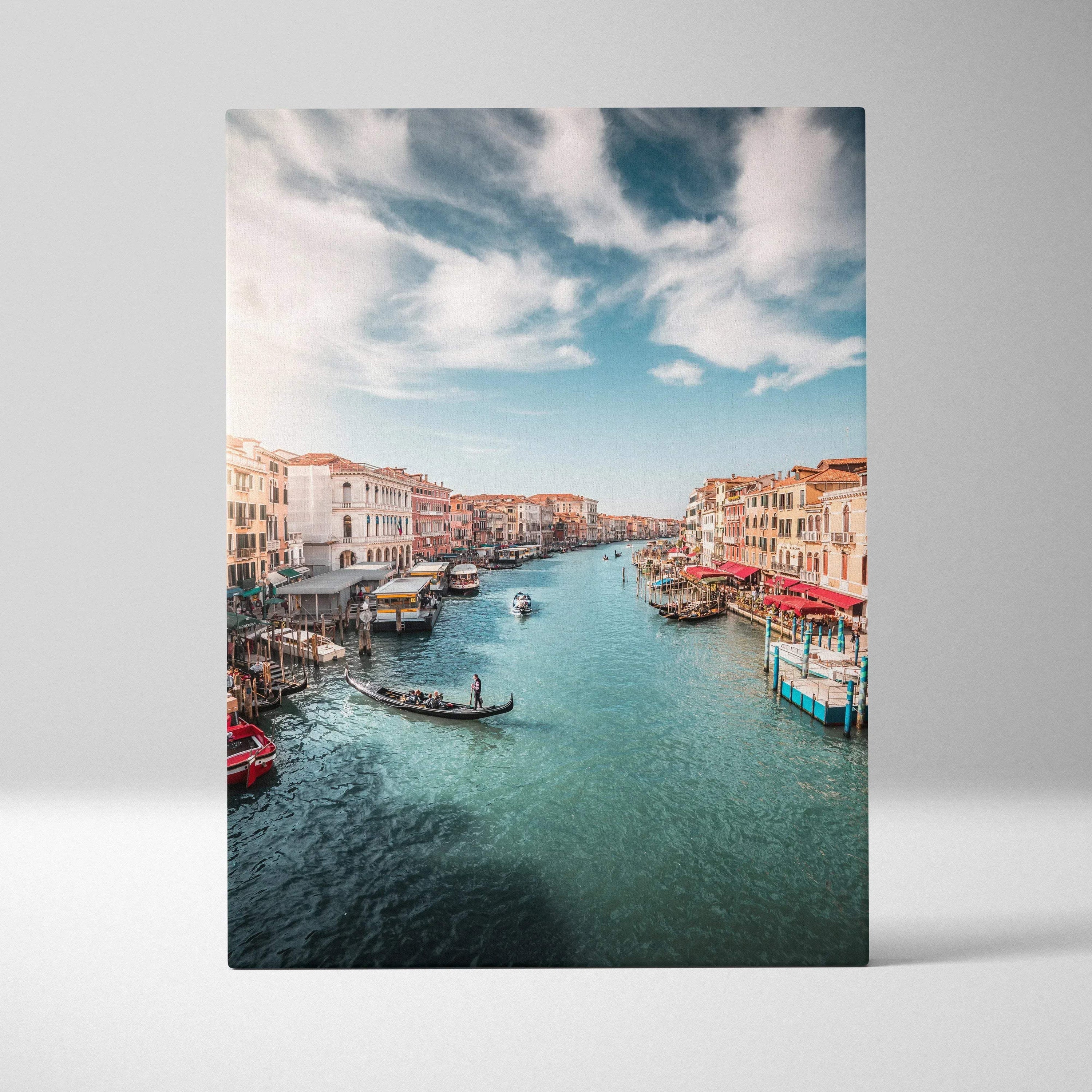 Vertical canvas wall art featuring a vibrant canal scene with buildings and boats under a blue sky.